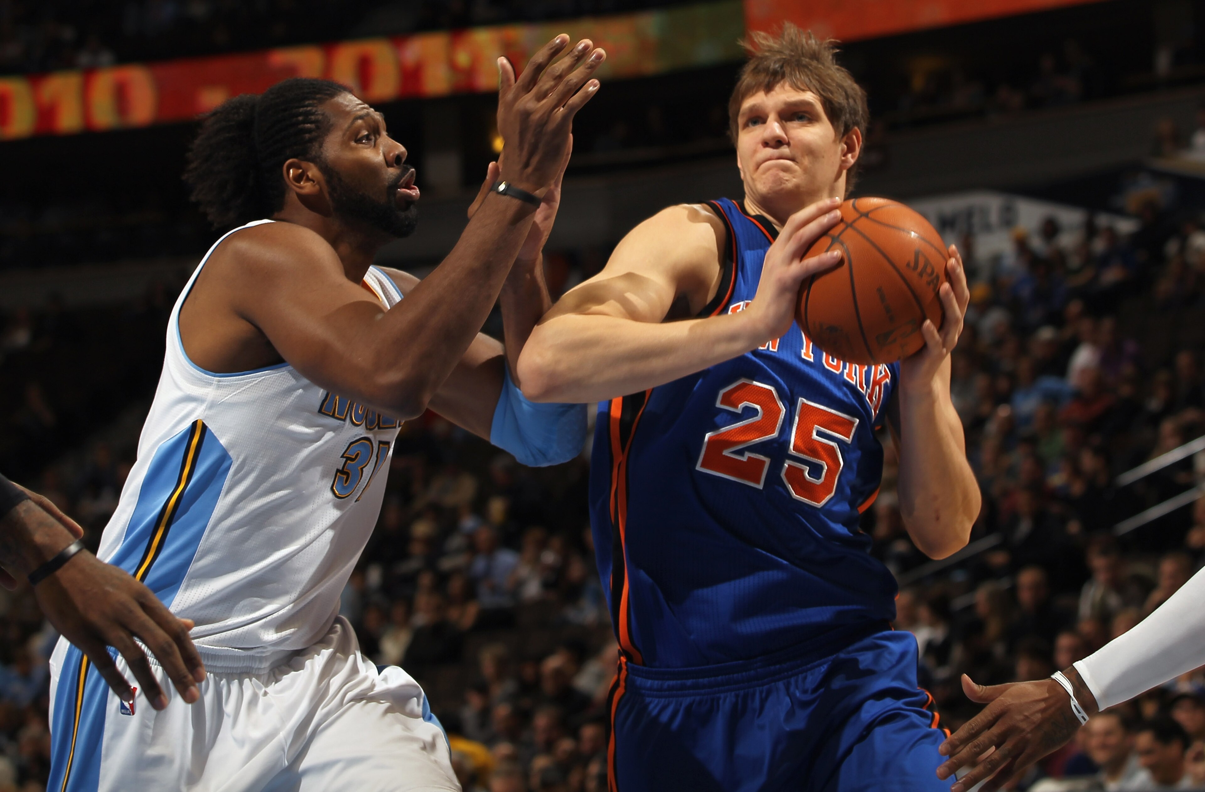 DENVER - NOVEMBER 16:  Timofey Mozgov #25 of the New York Knicks drives past Nene #31 of the Denver Nuggets at the Pepsi Center on November 16, 2010 in Denver, Colorado. NOTE TO USER: User expressly acknowledges and agrees that, by downloading and/or usin