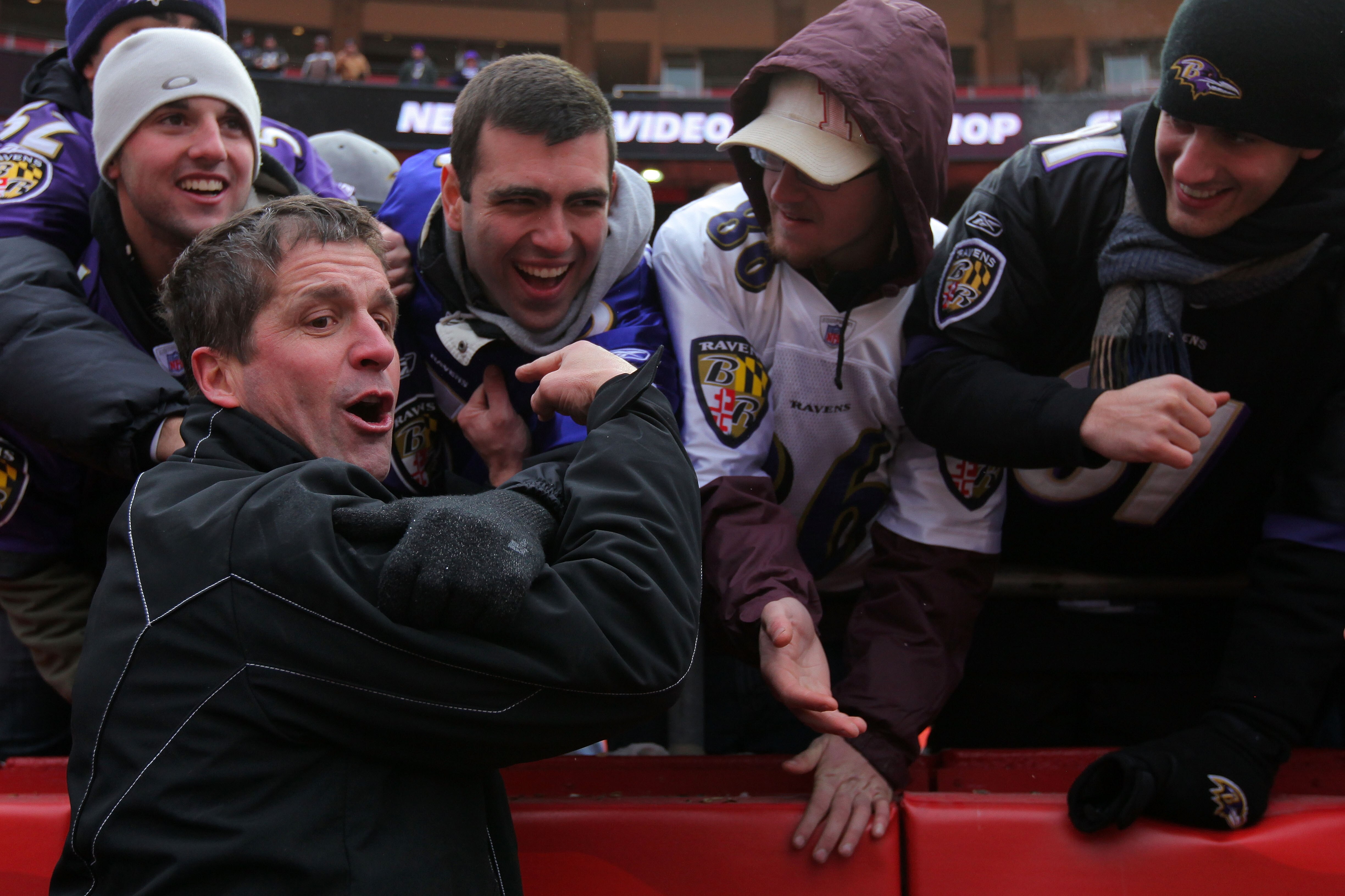 KANSAS CITY, MO - JANUARY 09:  Head coach John Harbaugh of the Baltimore Ravens celebrates with fans in the stands after defeating the Kansas City Chiefs 30-7 in the 2011 AFC wild card playoff game at Arrowhead Stadium on January 9, 2011 in Kansas City, M