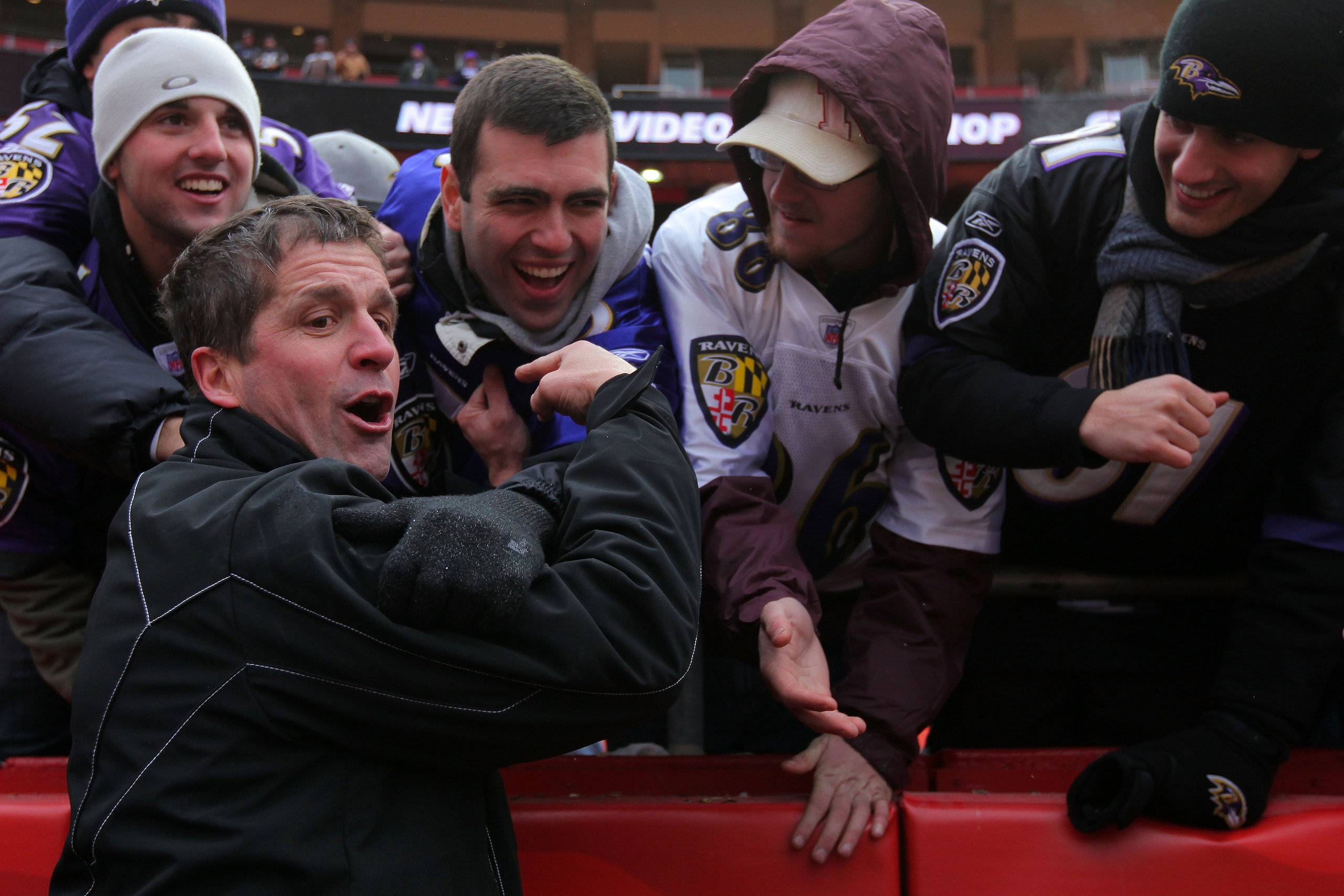 KANSAS CITY, MO - JANUARY 09:  Head coach John Harbaugh of the Baltimore Ravens celebrates with fans in the stands after defeating the Kansas City Chiefs 30-7 in the 2011 AFC wild card playoff game at Arrowhead Stadium on January 9, 2011 in Kansas City, M
