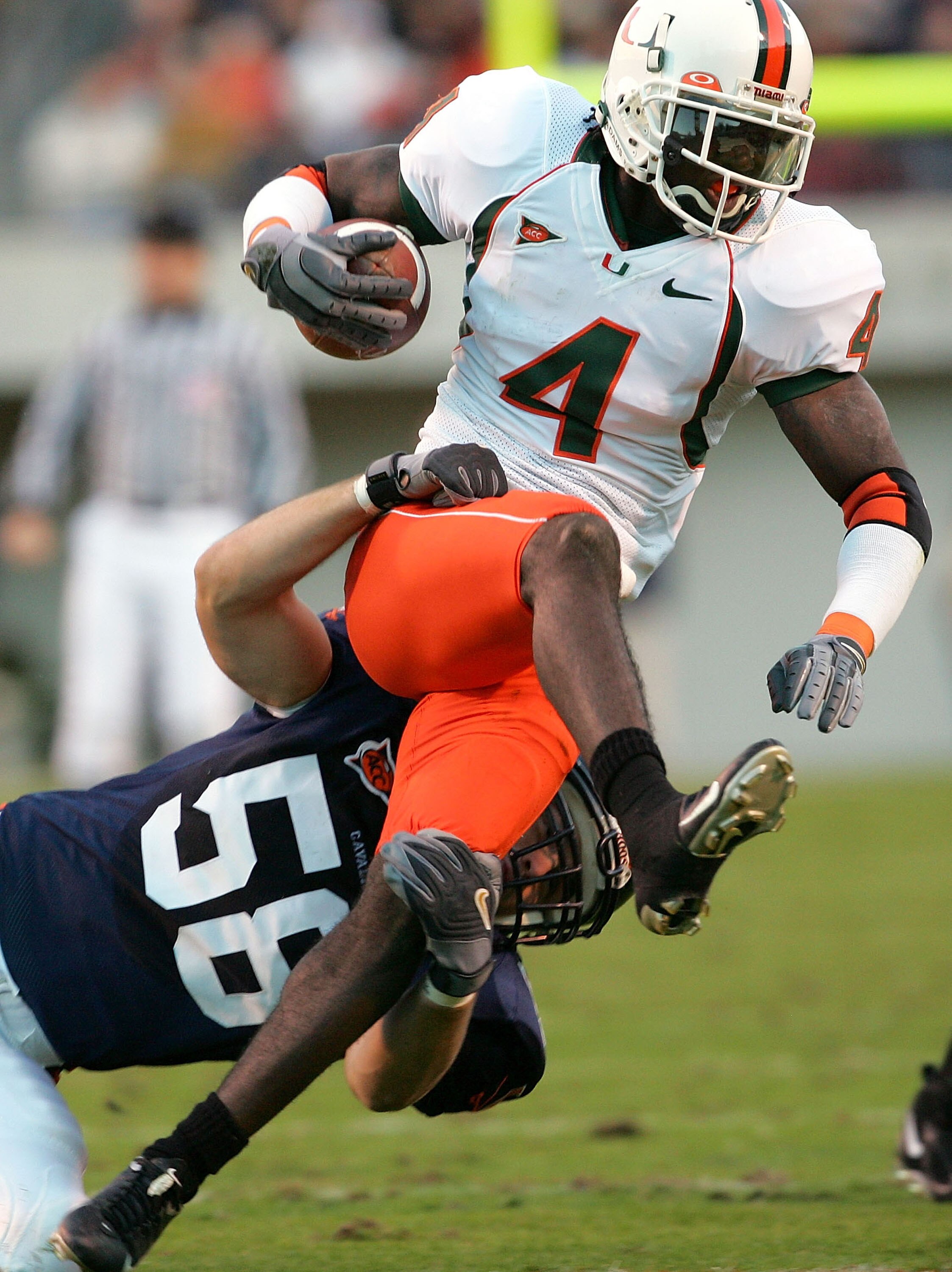 CHARLOTTESVILLE, VA - NOVEMBER 13:  Devin Hester #4 of the Miami Hurricanes carries the ball on a kickoff return as Jon Thompson #58 of the Virginia Cavaliers defends during the first half of the game on November 13, 2004 at David A. Harrison III Field at