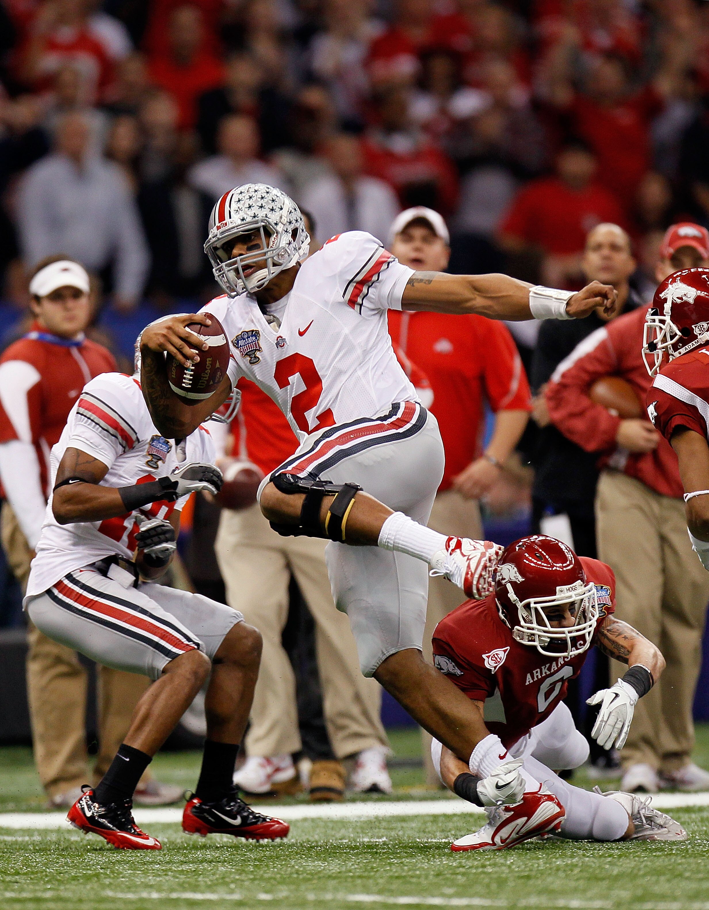 NEW ORLEANS, LA - JANUARY 04:  Terrelle Pryor #2 of the Ohio State Buckeyes runs with the football as he avoids a tackle by Isaac Madison #6 of the Arkansas Razorbacks in the first quarter during the Allstate Sugar Bowl at the Louisiana Superdome on Janua