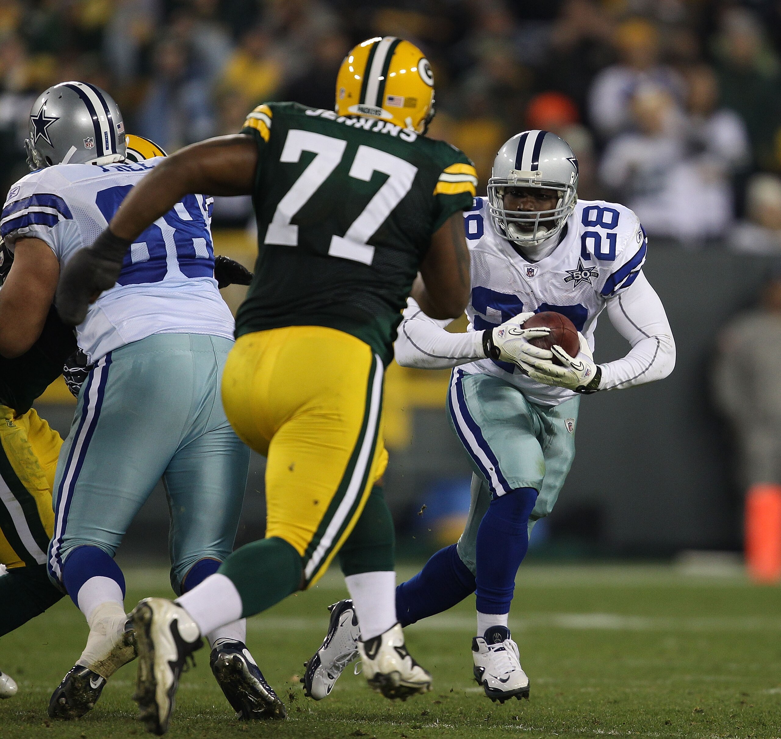 GREEN BAY, WI - NOVEMBER 07: Felix Jones #28 of the Dallas Cowboys runs after picking up a fumble as Cullen Jenkins #77 of the Green Bay Packers moves in for the tackle at Lambeau Field on November 7, 2010 in Green Bay, Wisconsin. The Packers defeated the