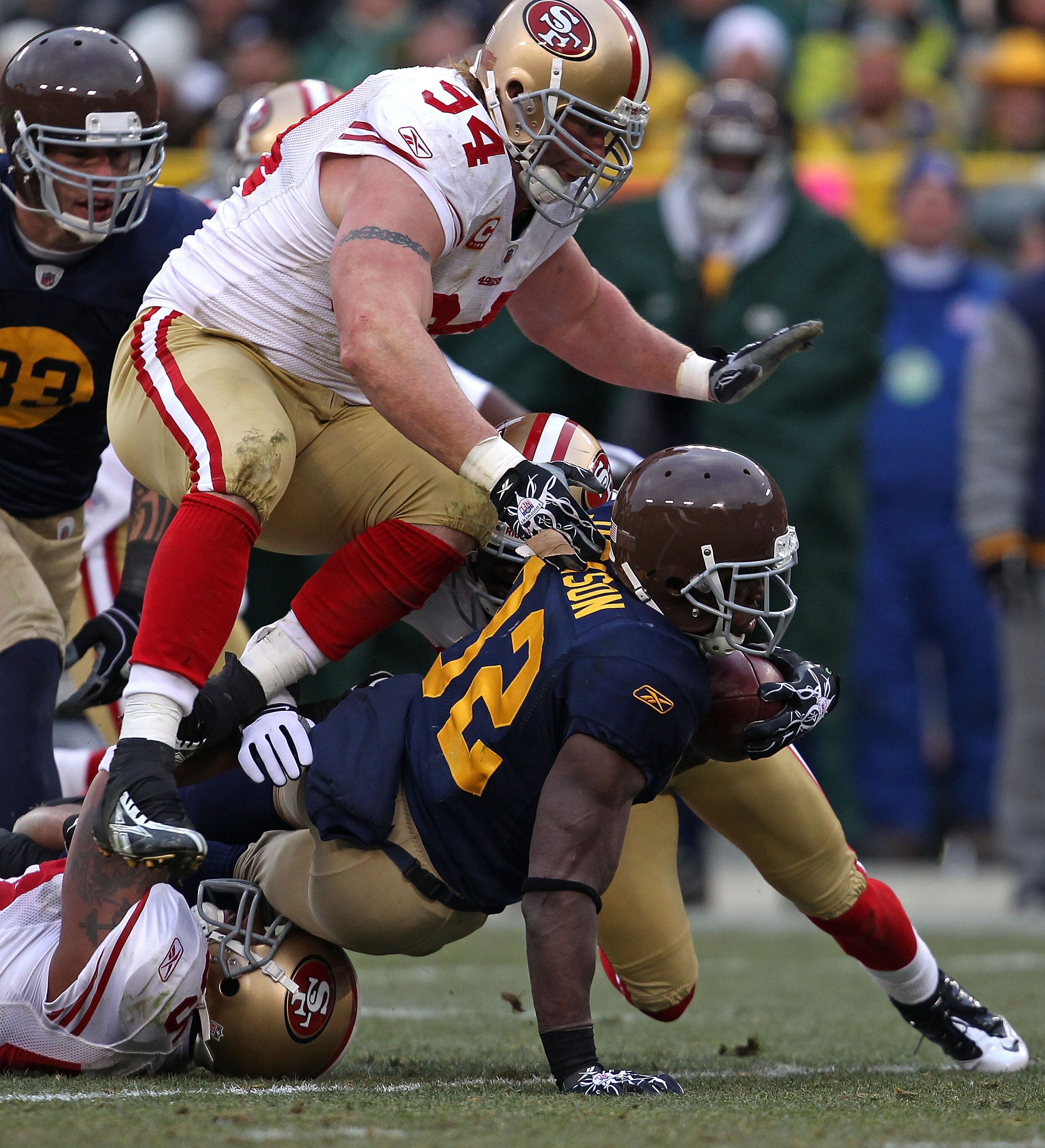 GREEN BAY, WI - DECEMBER 05: Brandon Jackson #32 of the Green Bay Packers is tackled by Shawntae Spencer #36 and Ahmad Brooks #55 of the San Francisco 49ers as Justin Smith #94 closes in at Lambeau Field on December 5, 2010 in Green Bay, Wisconsin. The Pa