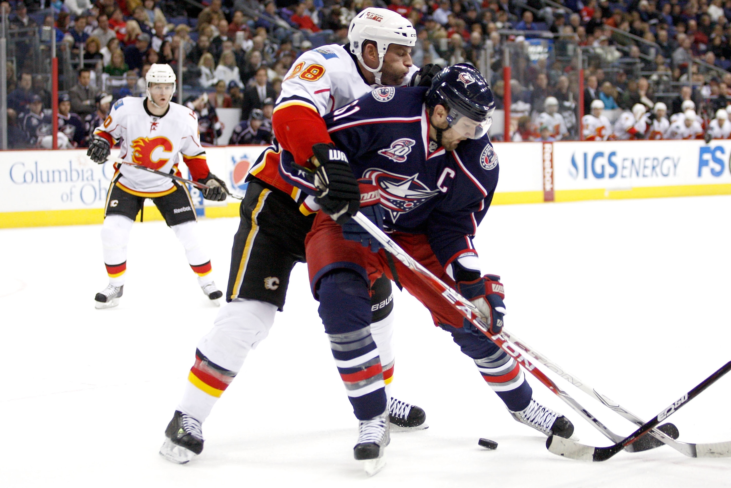 COLUMBUS, OH - DECEMBER 21:  Robyn Regehr #28 of the Calgary Flames and Rick Nash #61 of the Columbus Blue Jackets battle for control of a loose puck during the second period on December 21, 2010 at Nationwide Arena in Columbus, Ohio.  (Photo by John Grie