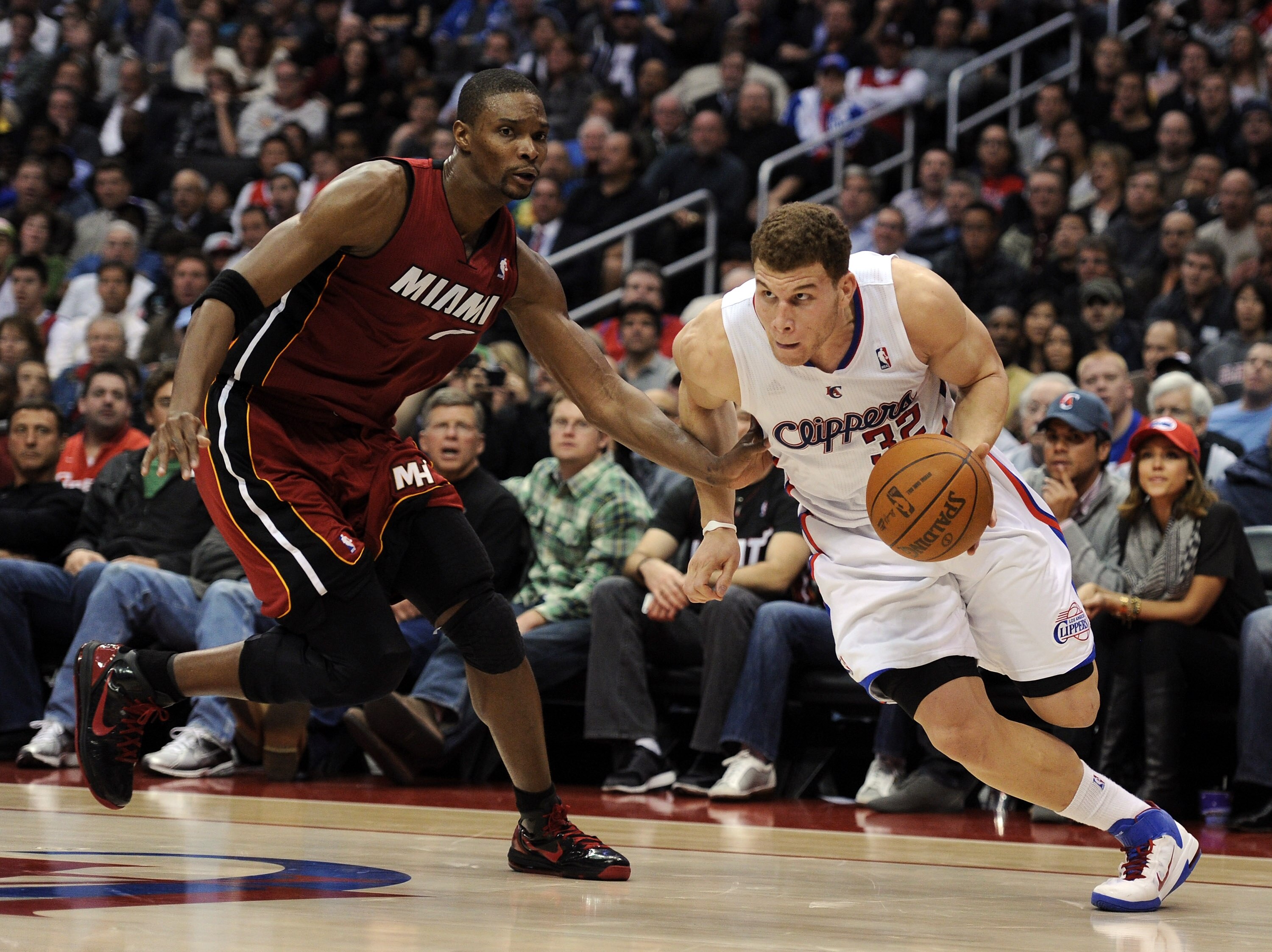 LOS ANGELES, CA - JANUARY 12:  Blake Griffin #32 of the Los Angeles Clippers dribbles around Chris Bosh #1 of the Miami Heat at Staples Center on January 12, 2011 in Los Angeles, California.  NOTE TO USER: User expressly acknowledges and agrees that, by d