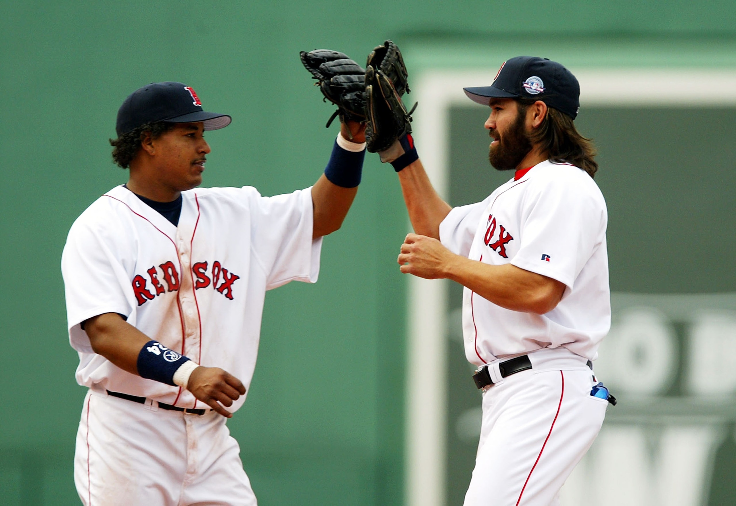 BOSTON - APRIL 17:  Manny Ramirez #24 and Johnny Damon #18 of the Boston Red Sox high-five after they beat the New York Yankees on April 17, 2004 at Fenway Park in Boston, Massachusetts. The Red Sox won 5-2.  (Photo by Ezra Shaw/Getty Images)
