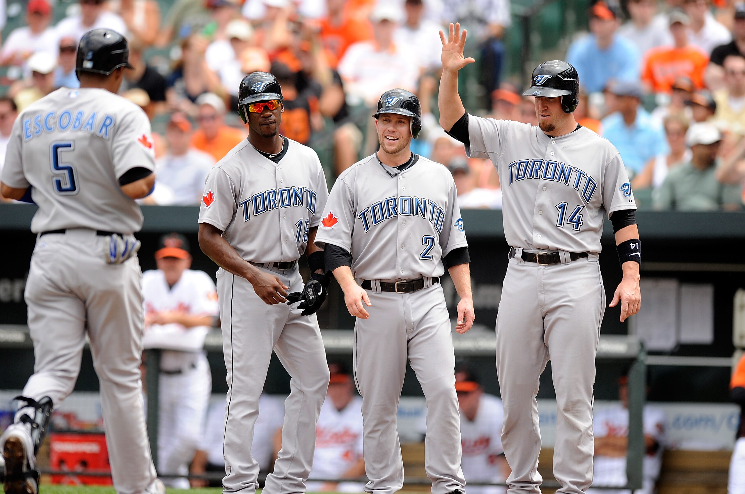 BALTIMORE - JULY 18:  Yunel Escobar #5 of the Toronto Blue Jays is congratulated by Fred Lewis #15, Aaron Hill #2 and John Buck #14 after hitting a grand slam home run in the second inning against the Baltimore Orioles at Camden Yards on July 18, 2010 in