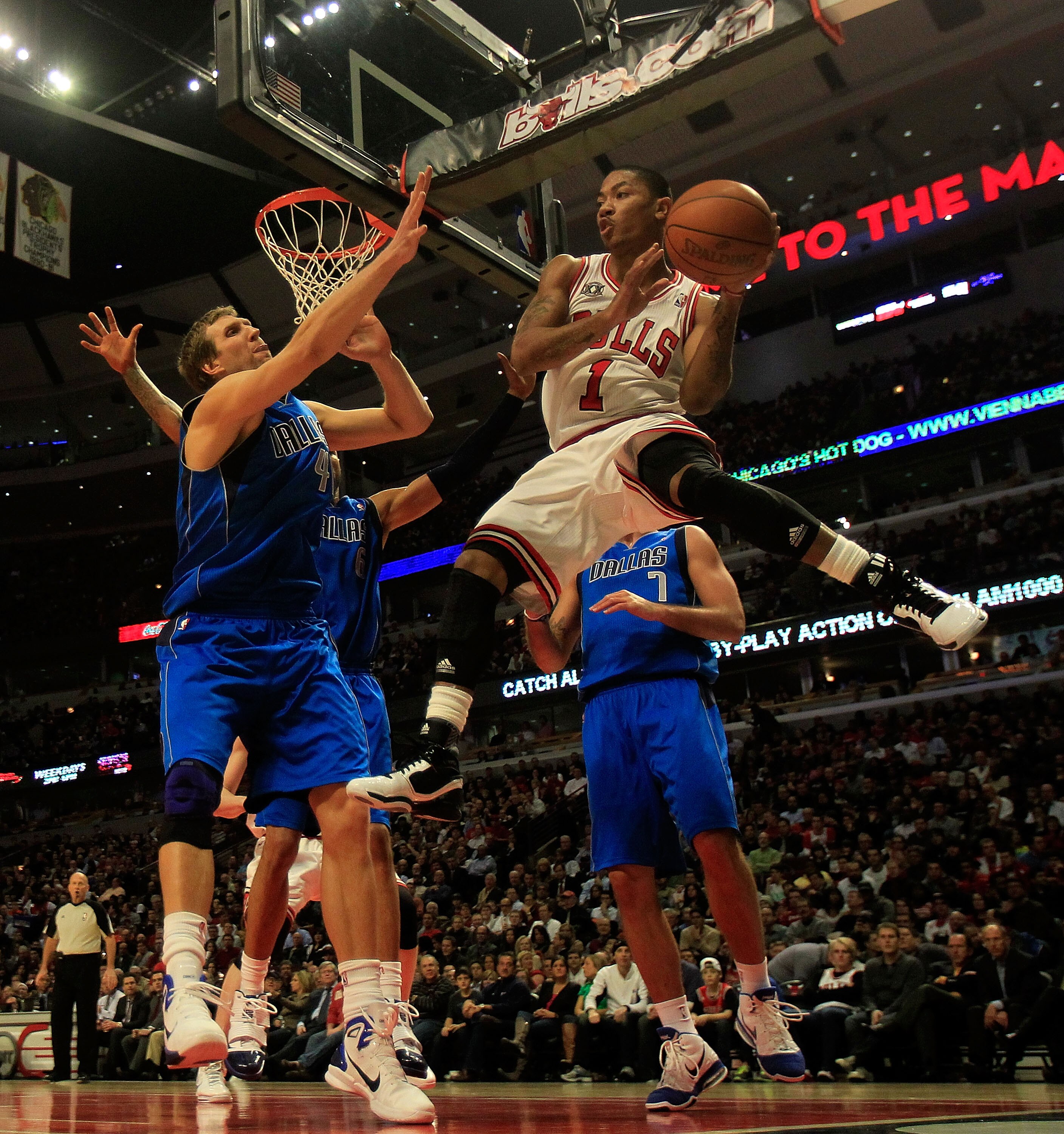 CHICAGO, IL - JANUARY 20: Derrick Rose #1 of the Chicago Bulls leaps to pass the ball around Dirk Nowitzki #41 of the Dallas Mavericks at the United Center on January 20, 2011 in Chicago, Illinois. The Bulls defeated the Mavericks 82-77. NOTE TO USER: Use