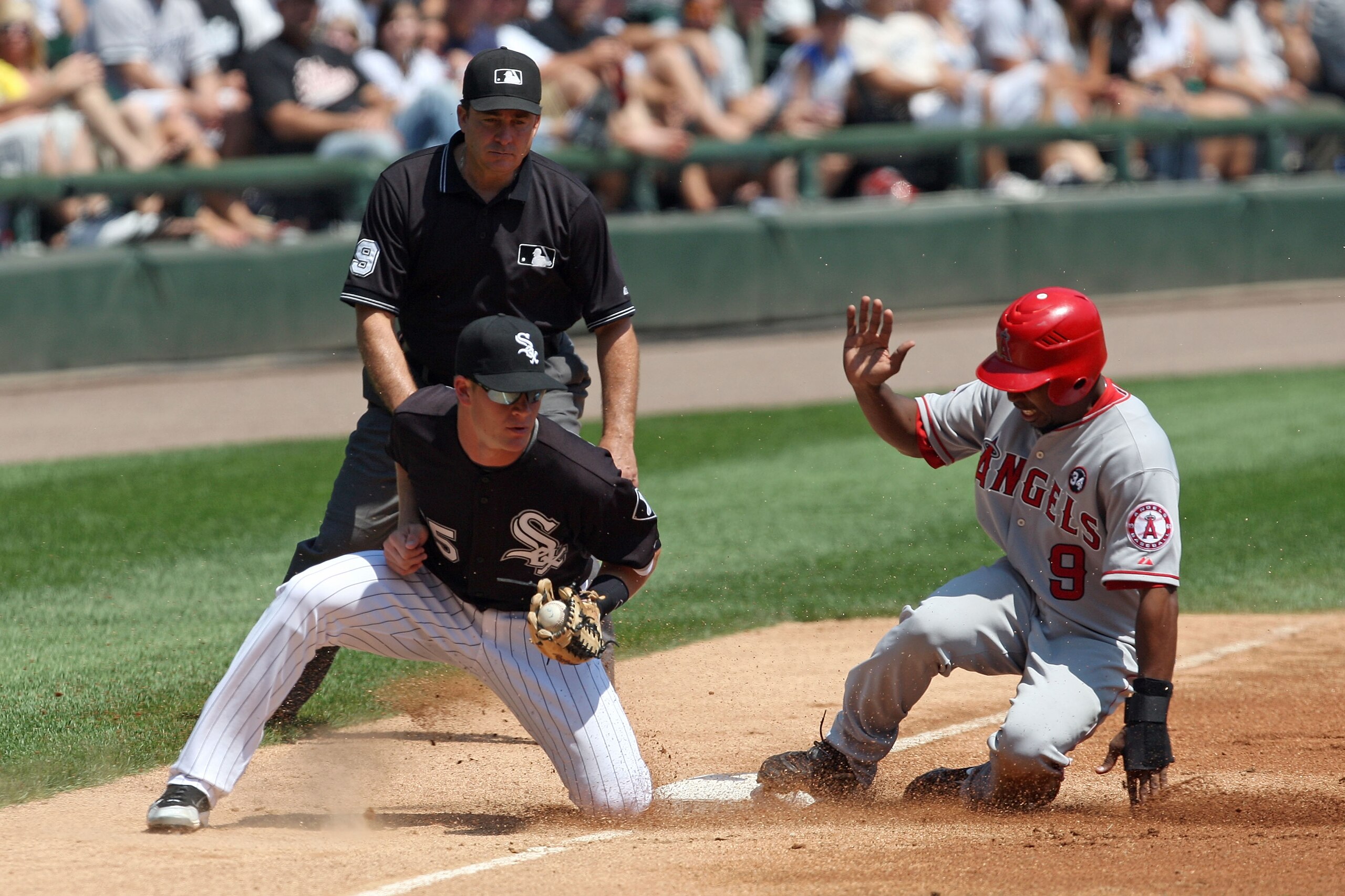 CHICAGO - AUGUST 06:  Chone Figgins #9 of the Los Angeles Angels of Anaheim successfully steals third base in the top of the second inning against Gordon Beckham #15 of the Chicago White Sox at U.S. Cellular Field on August 6, 2009 in Chicago, Illinois.