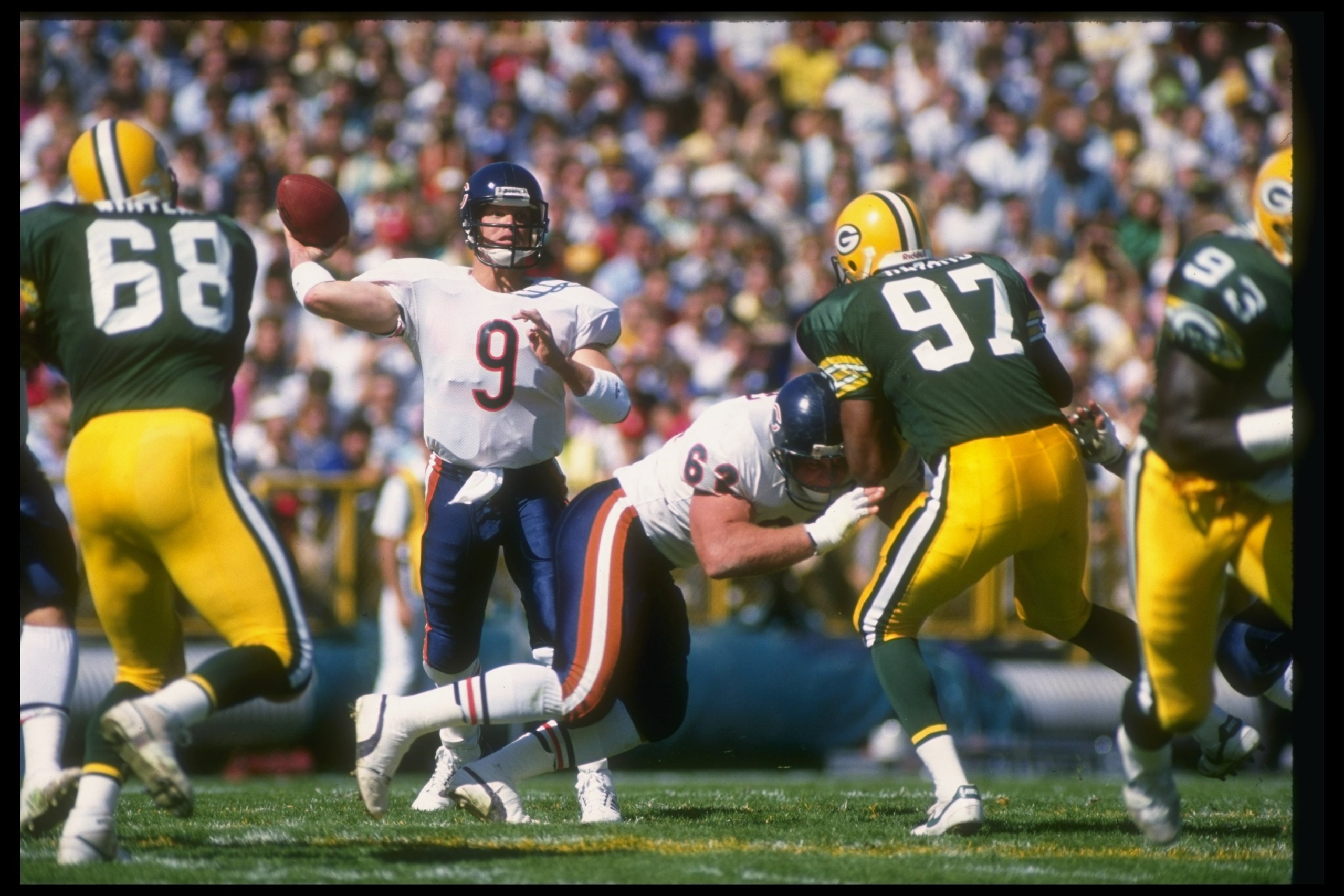 25 Sep 1988: Quarterback Jim McMahon of the Chicago Bears (center) looks to pass against the Green Bay Packers during a game at Lambeau Field in Green Bay, Wisconsin. The Bears won the game, 24-6.