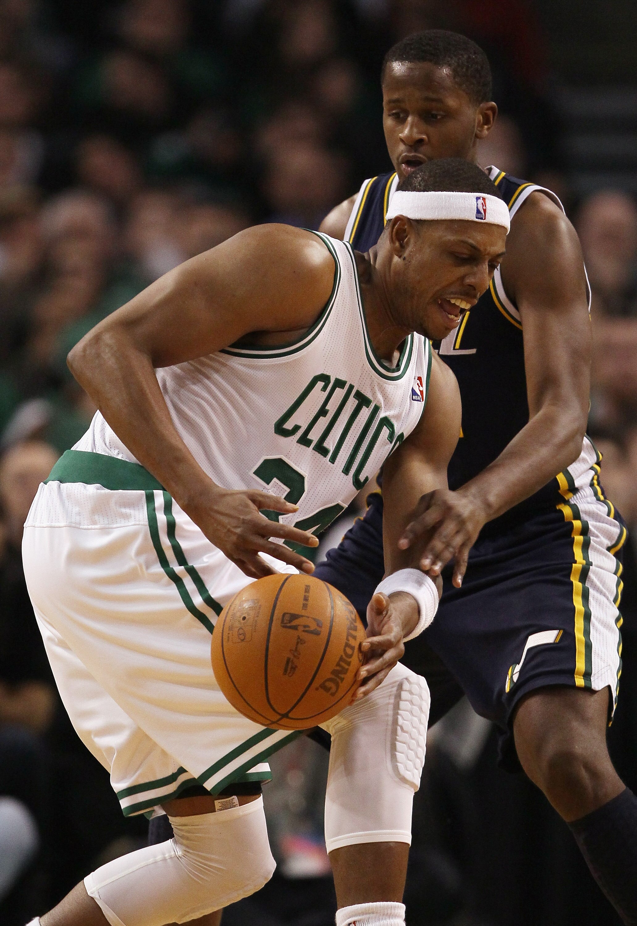 BOSTON, MA - JANUARY 21:  Paul Pierce #34 of the Boston Celtics tries to keep the ball as he is hit by C.J. Miles #34  of the Utah Jazz on January 21, 2011 at the TD Garden in Boston, Massachusetts.  NOTE TO USER: User expressly acknowledges and agrees th