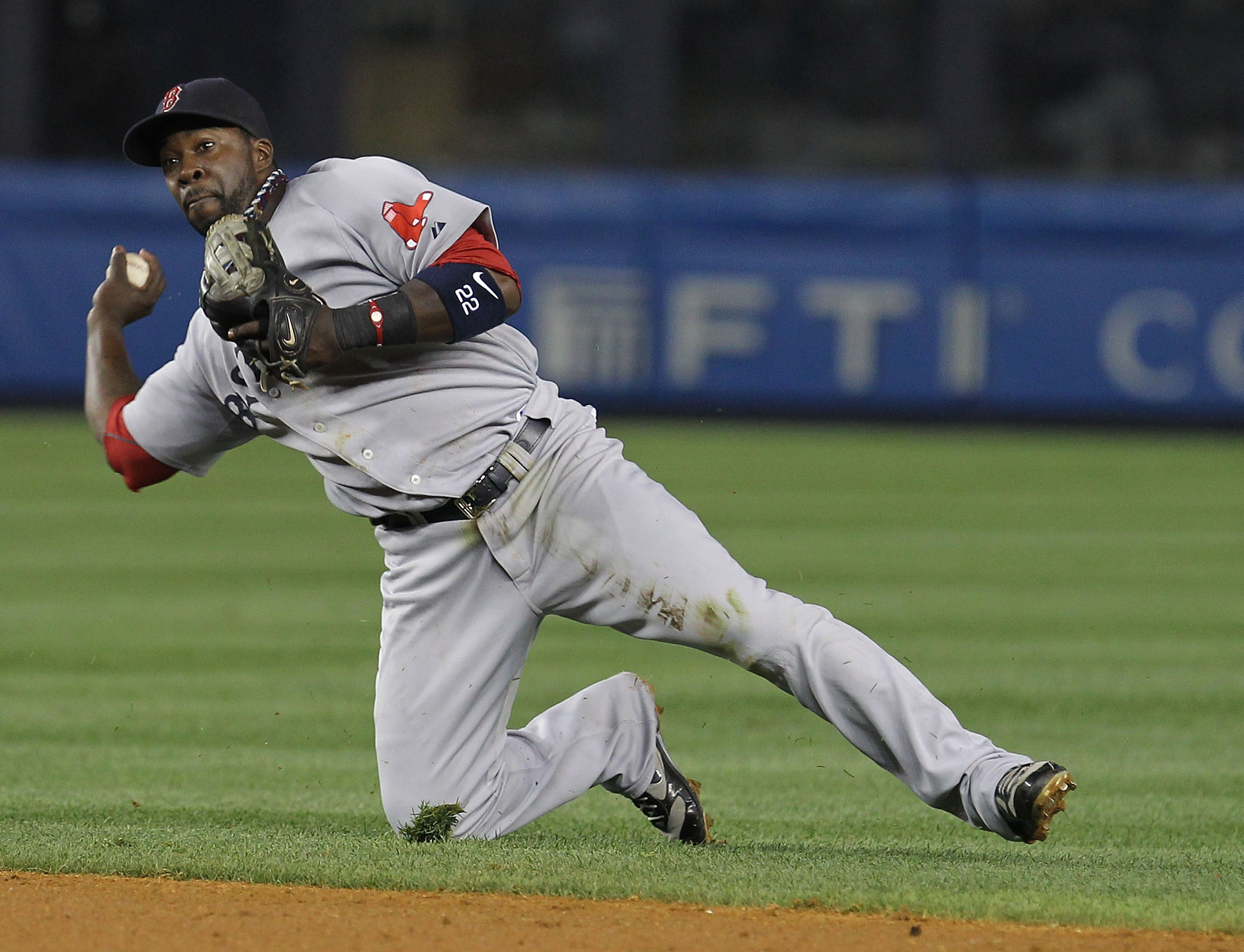 NEW YORK - AUGUST 08:  Bill Hall #22 of the Boston Red Sox throws the ball away as Brett Gardner of the New York Yankees reaches first and a run scores during their game on August 8, 2010 at Yankee Stadium in the Bronx borough of New York City.  (Photo by