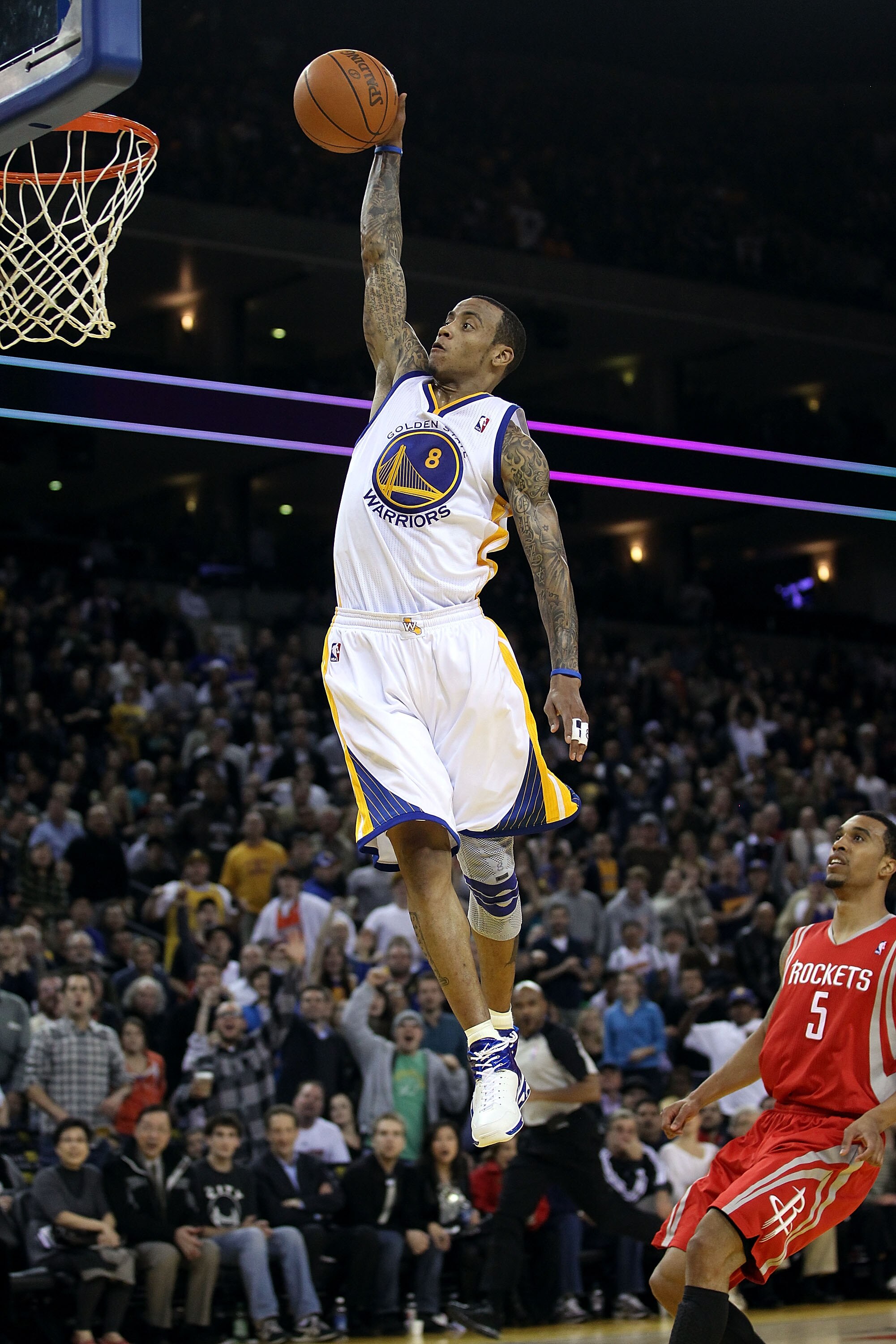 OAKLAND, CA - DECEMBER 20:  Monta Ellis #8 of the Golden State Warriors dunks the ball over Courtney Lee #5 of the Houston Rockets at Oracle Arena on December 20, 2010 in Oakland, California. NOTE TO USER: User expressly acknowledges and agrees that, by d