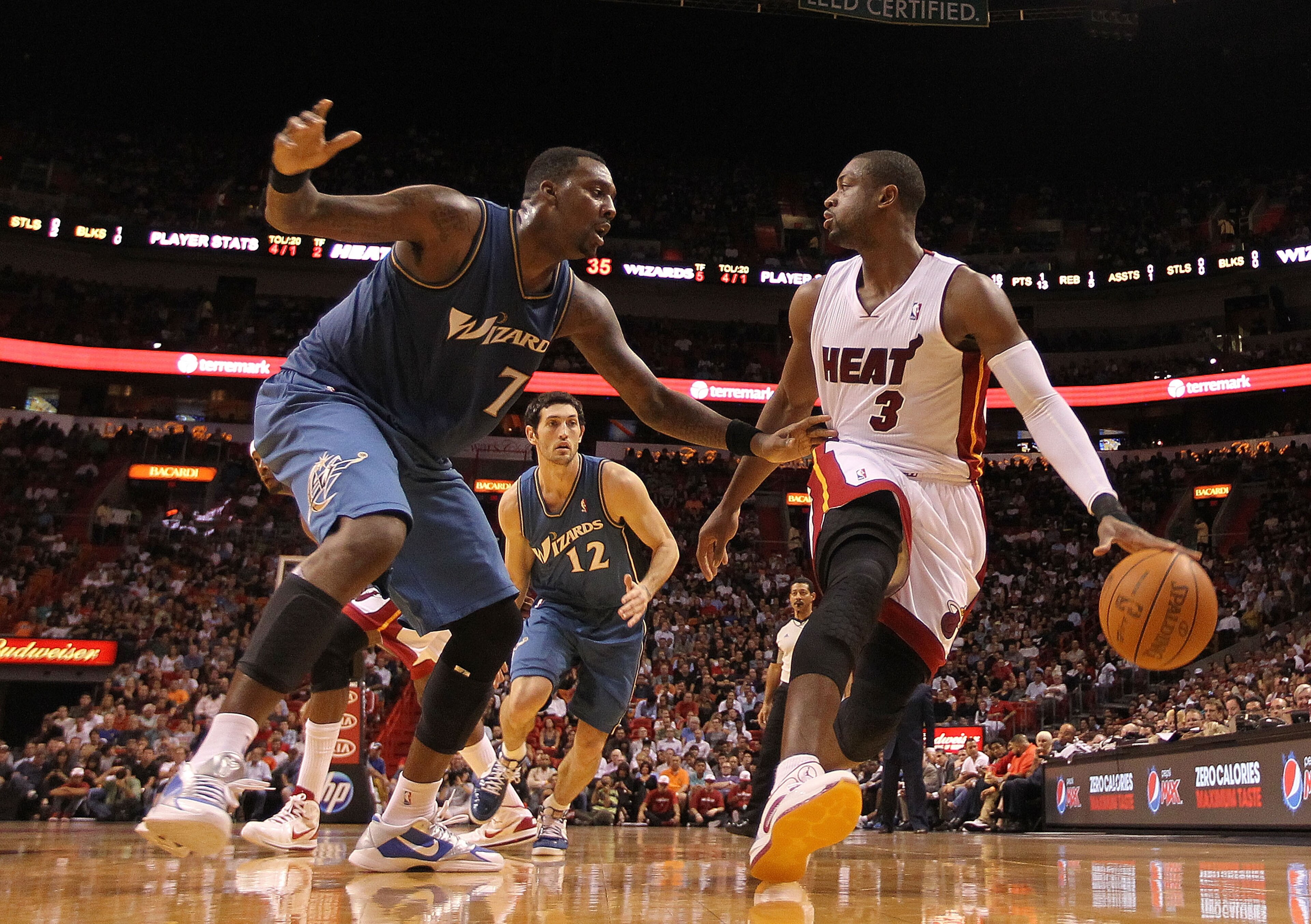 MIAMI, FL - NOVEMBER 29:  Dwyane Wade #3 of the Miami Heat dribbles around Andray Blatche #7 of the Washington Wizards  during a game at American Airlines Arena on November 29, 2010 in Miami, Florida. NOTE TO USER: User expressly acknowledges and agrees t