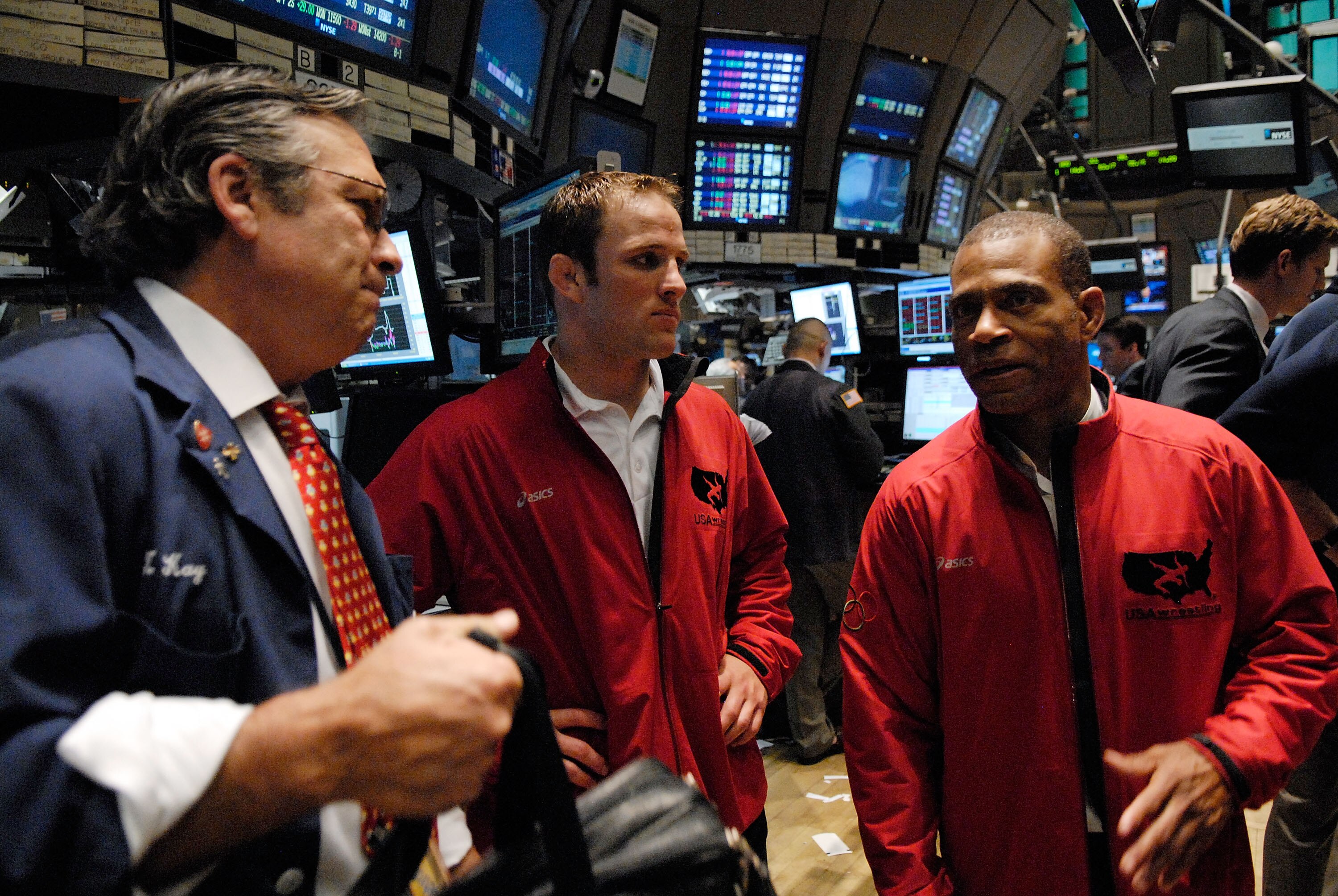 NEW YORK - JUNE 20: U.S. National Wrestling Team member Brad Vering (C) and freestyle coach Lee Kemp (R) talk to a trader on the floor of the New York Stock Exchange June 20, 2008 in New York City. (Photo by Jonathan Fickies/Getty Images)