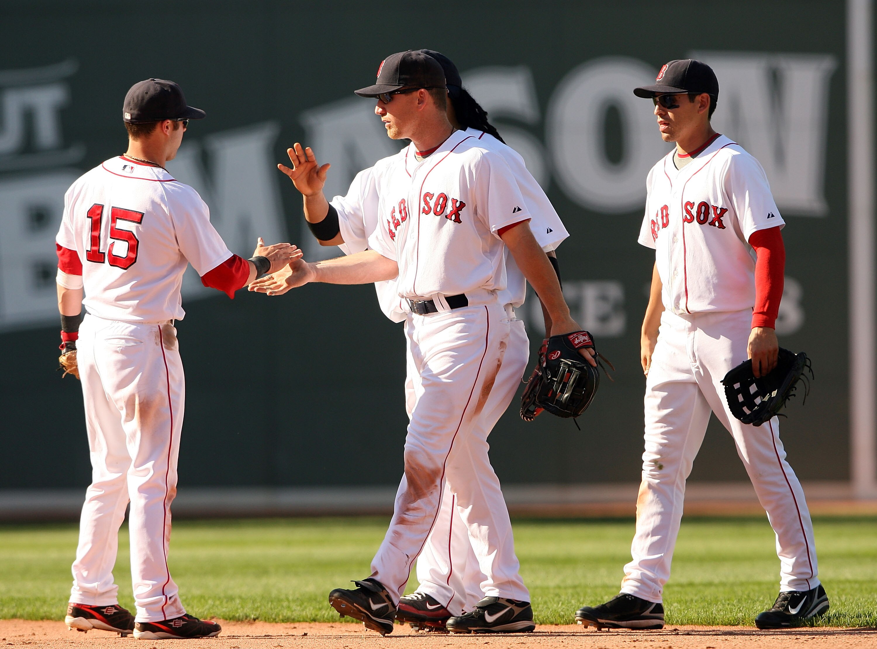 BOSTON - JULY 13:  Dustin Pedroia #15 of the Boston Red Sox is congratulated by teammates J.D. Drew #7, Jacoby Ellsbury #46 and Manny Ramirez #24 after Pedroia made the catch for the final out of the game  on July 13, 2008 at Fenway Park in Boston, Massac