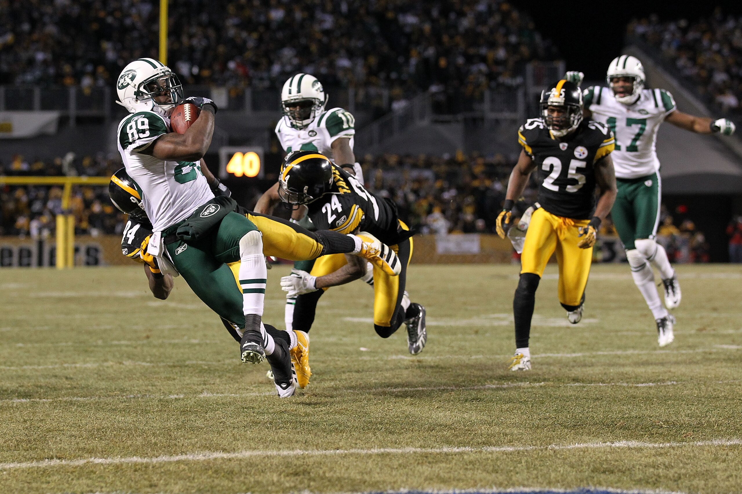 PITTSBURGH, PA - JANUARY 23:  Jerricho Cotchery #89 of the New York Jets is tackled by Ike Taylor #24 and Lawrence Timmons #94 of the Pittsburgh Steelers during the fourth quarter of the 2011 AFC Championship game at Heinz Field on January 23, 2011 in Pit