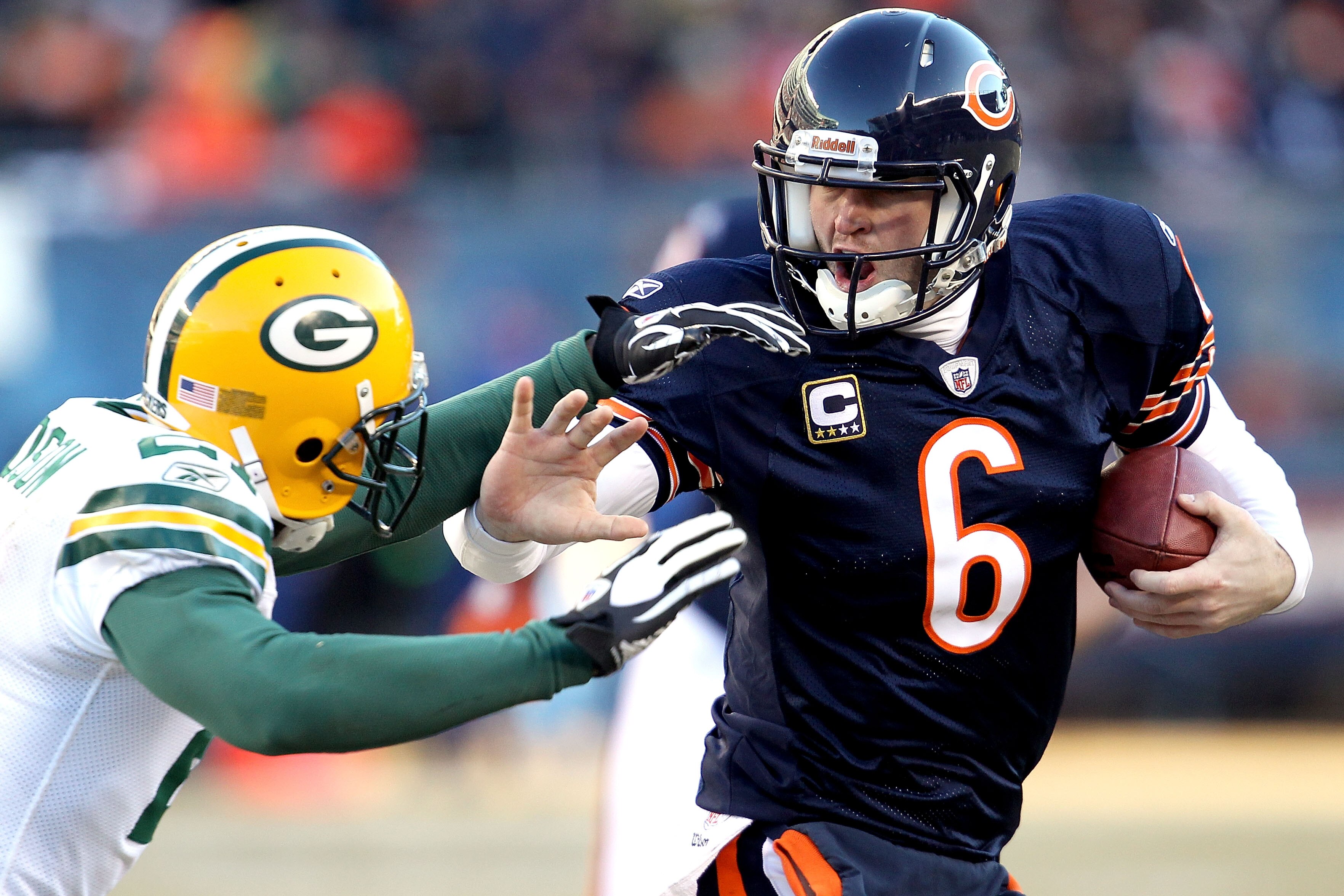 CHICAGO, IL - JANUARY 23:  Quarterback Jay Cutler #6 of the Chicago Bears throws out his right arm to avoid a tackle by Charles Woodson #21 of the Green Bay Packers in the second quarter of the NFC Championship Game at Soldier Field on January 23, 2011 in