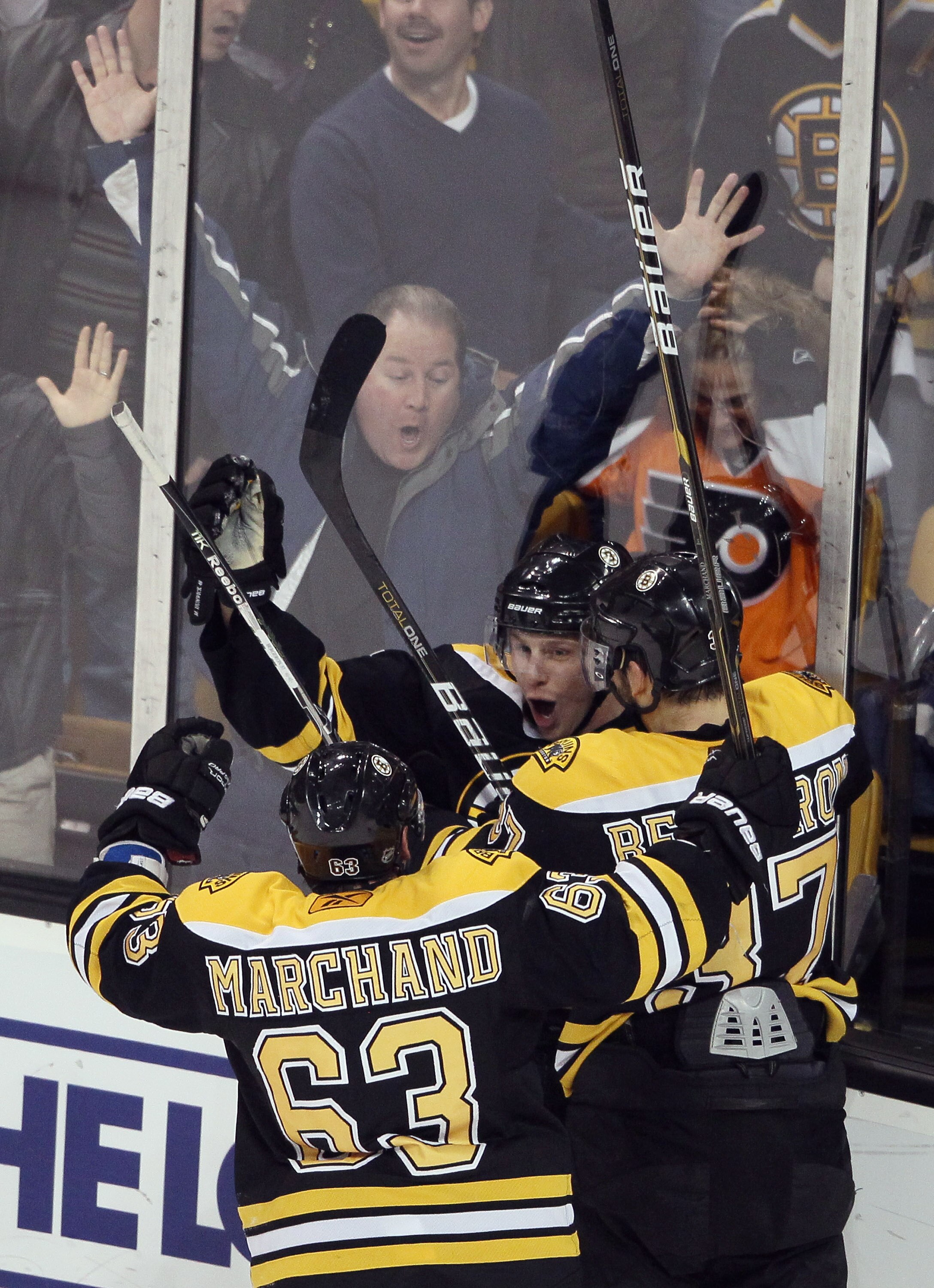 BOSTON, MA - JANUARY 13:   Steven Kampfer #47 of the Boston Bruins is congratulated by Brad Marchand #63 and Patrice Bergeron #37 after Kampfer scored the game winner against the Philadelphia Flyers on January 13, 2011 at the TD Garden in Boston, Massachu
