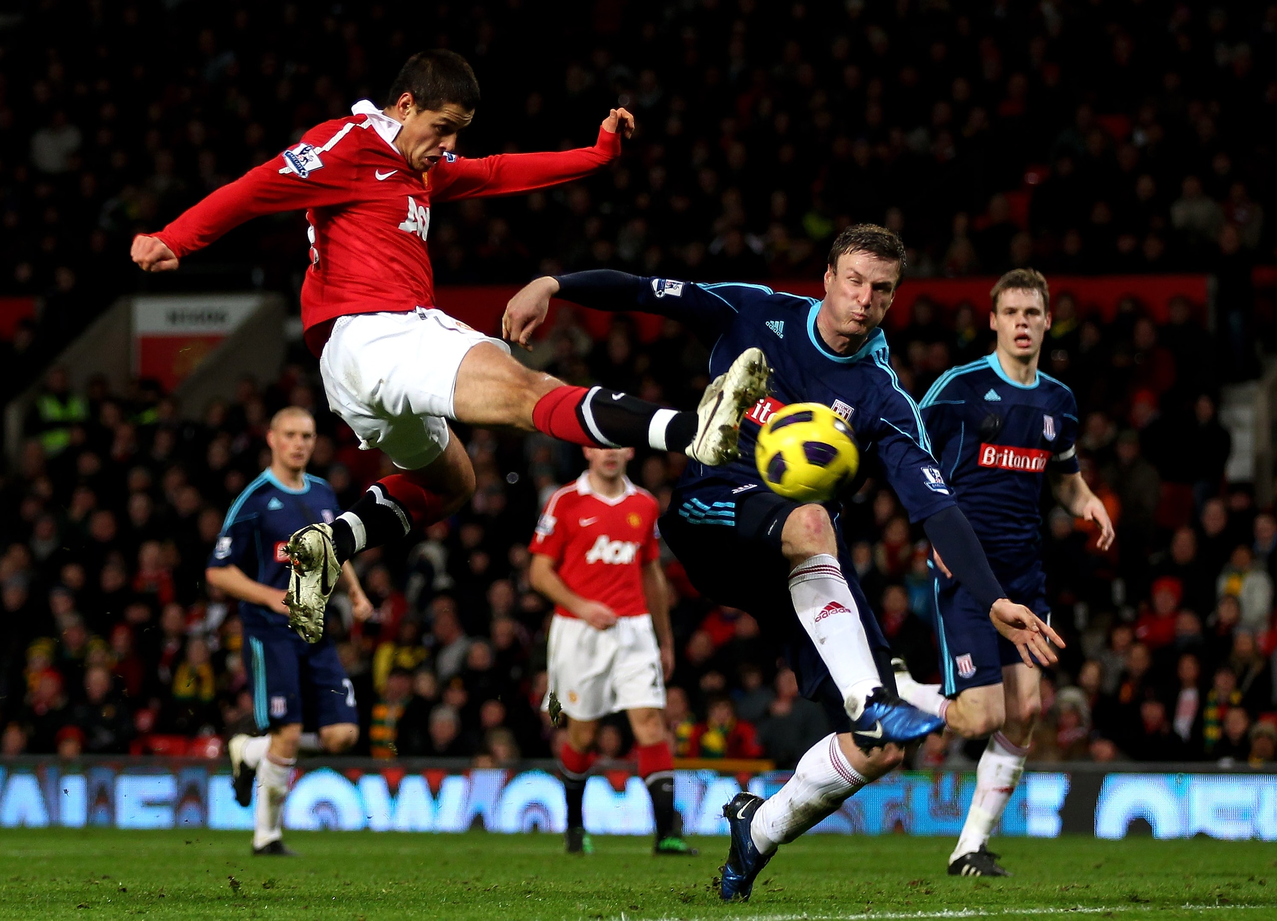 MANCHESTER, ENGLAND - JANUARY 04:  Javier Hernandez of Manchester United shoots at goal under pressure from Robert Huth of Stoke City during the Barclays Premier League match between Manchester United and Stoke City at Old Trafford on January 4, 2011 in M