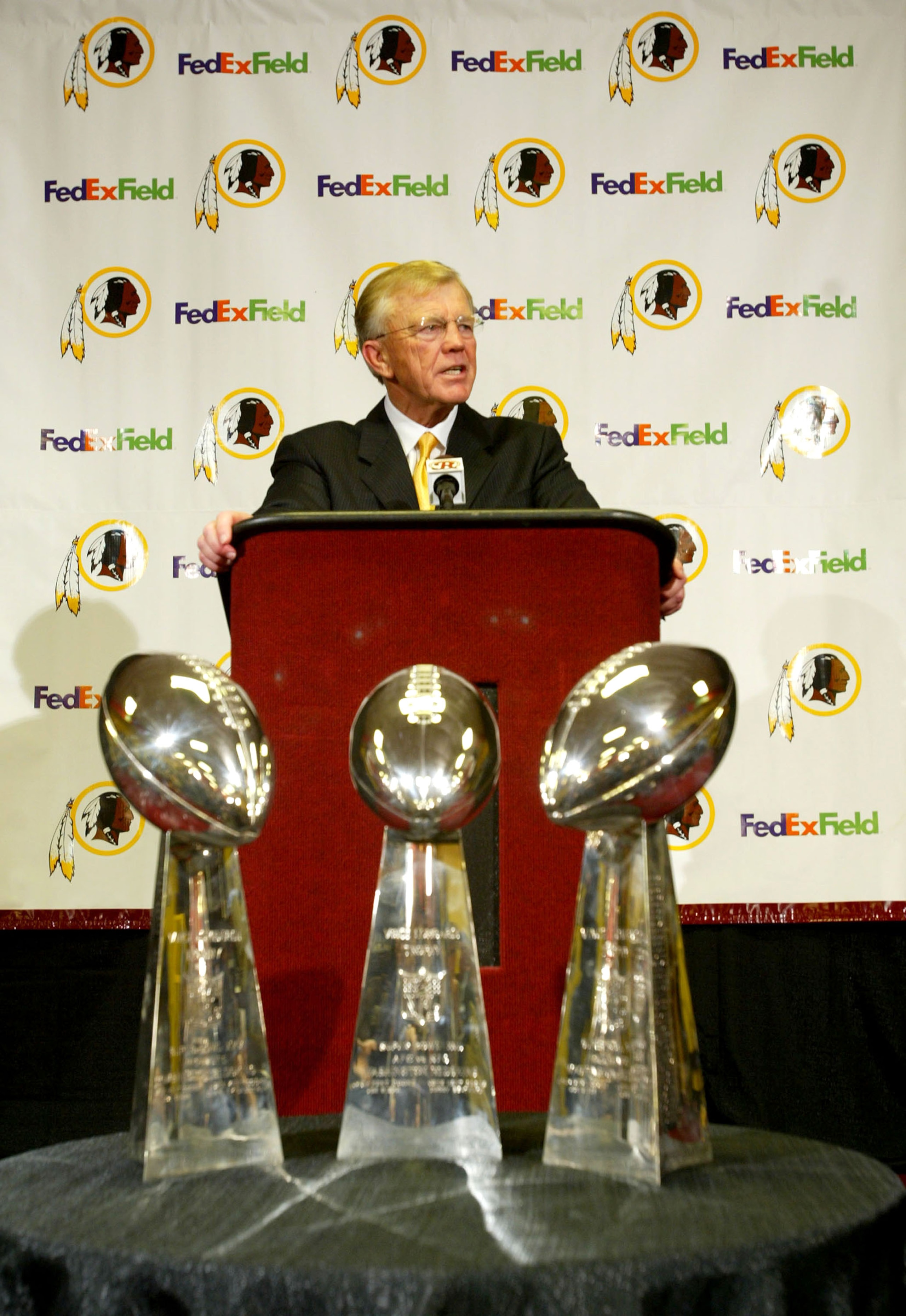 ASHBURN, VA - JANUARY 8: Joe Gibbs addresses the media as he is announced as the new head coach of the Washington Redskins at a media conference on January 8, 2004 at Redskins Park in Ashburn, Virginia. The Redskins organizations' three Super Bowl Trophi ASHBURN, VA - JANUARY 8: Joe Gibbs addresses the media as he is announced as the new head coach of the Washington Redskins at a media conference on January 8, 2004 at Redskins Park in Ashburn, Virginia. The Redskins organizations' three Super Bowl Trophi