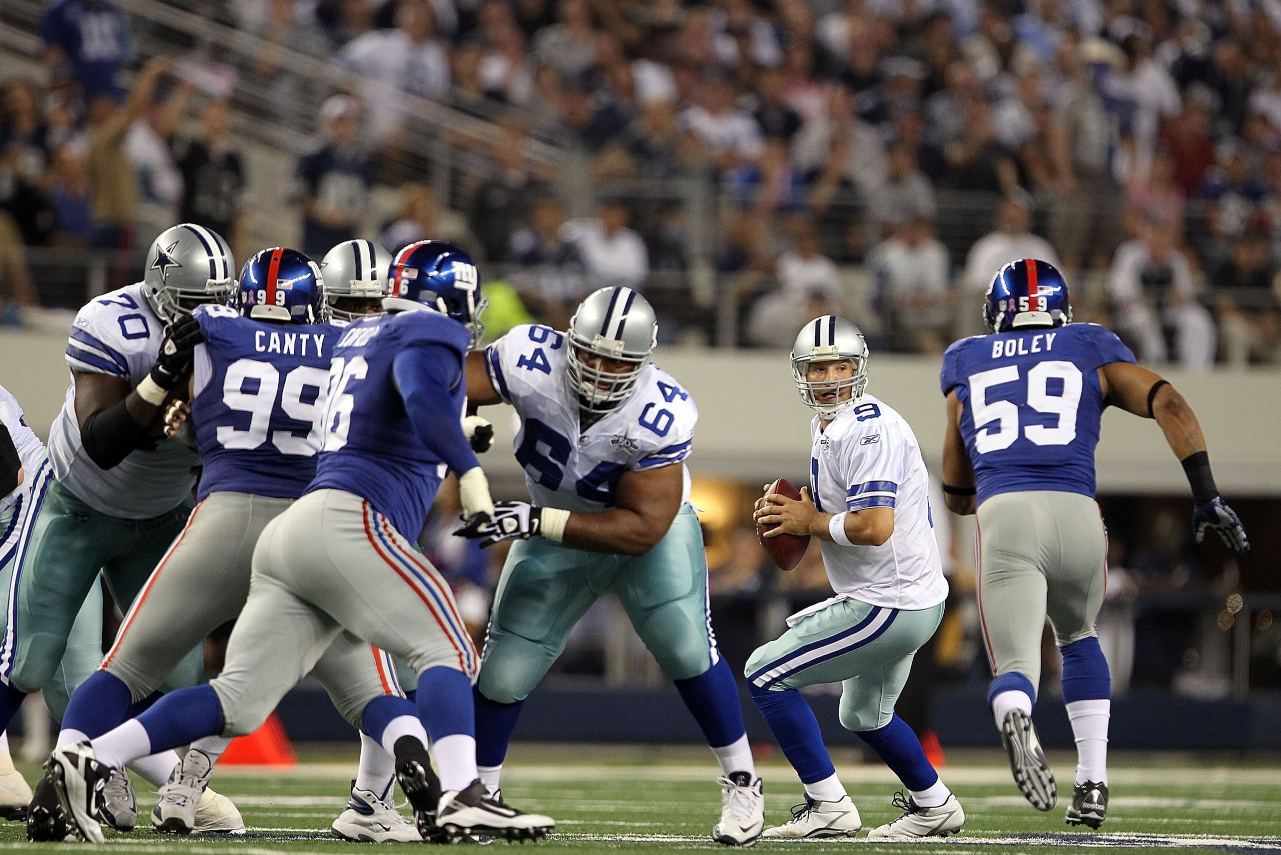 ARLINGTON, TX - OCTOBER 25:  Quarterback Tony Romo #9 of the Dallas Cowboys drops back to pass before a hit by Michael Boley #59 of the New York Giants in the second quarter at Cowboys Stadium on October 25, 2010 in Arlington, Texas.  Romo did not return