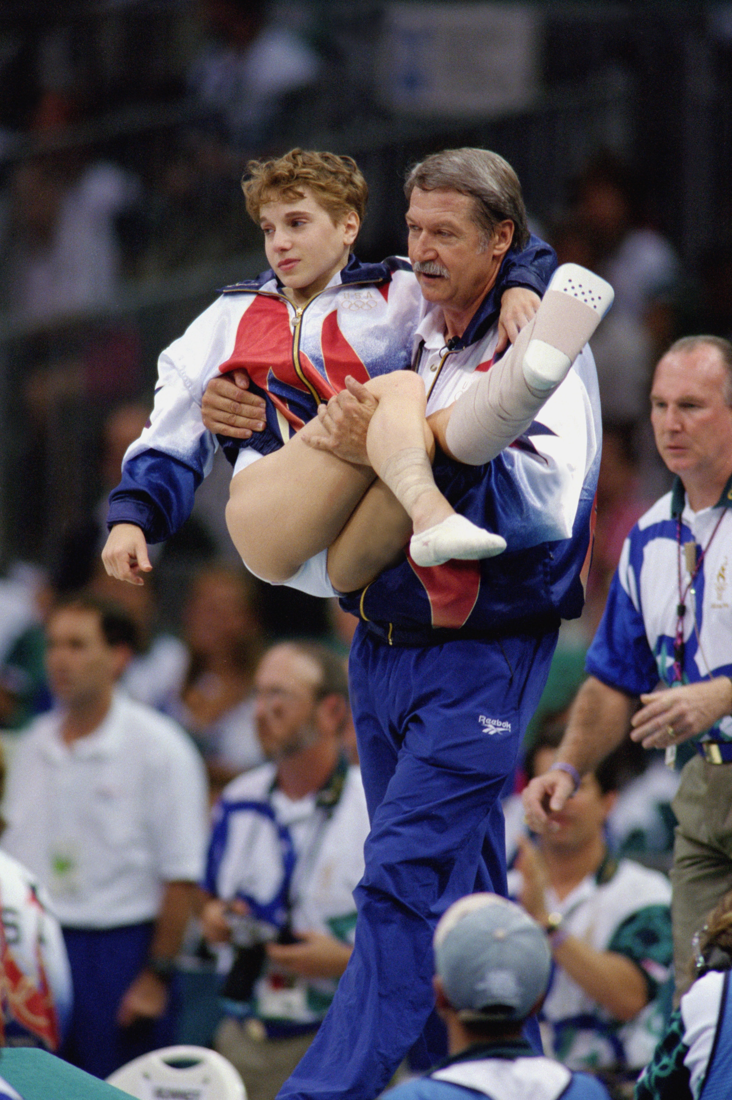 ATLANTA - JULY 23:  Coach Bela Karolyi carries Kerri Strug of the United States after she injured herself on her first attempt while competing in the vault, part of the Womens Team Gymnastics competition at the 1996 Olympic Games on July 23, 1996 at the G