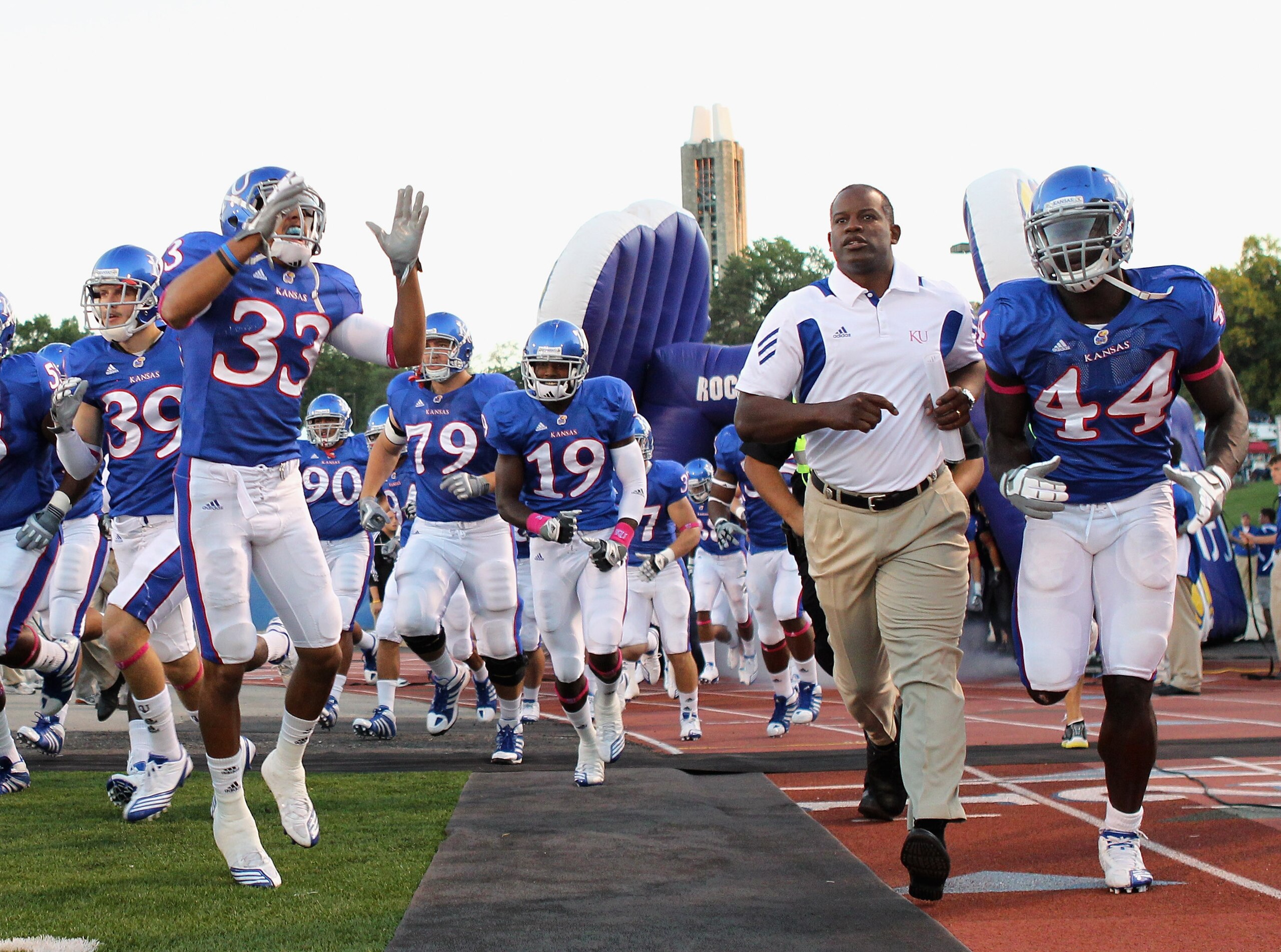 LAWRENCE, KS - OCTOBER 14:  Head coach Turner Gill of the Kansas Jayhawks trots onto the field ahead of the game against the Kansas State Wildcats on October 14, 2010 at Memorial Stadium in Lawrence, Kansas.  (Photo by Jamie Squire/Getty Images)