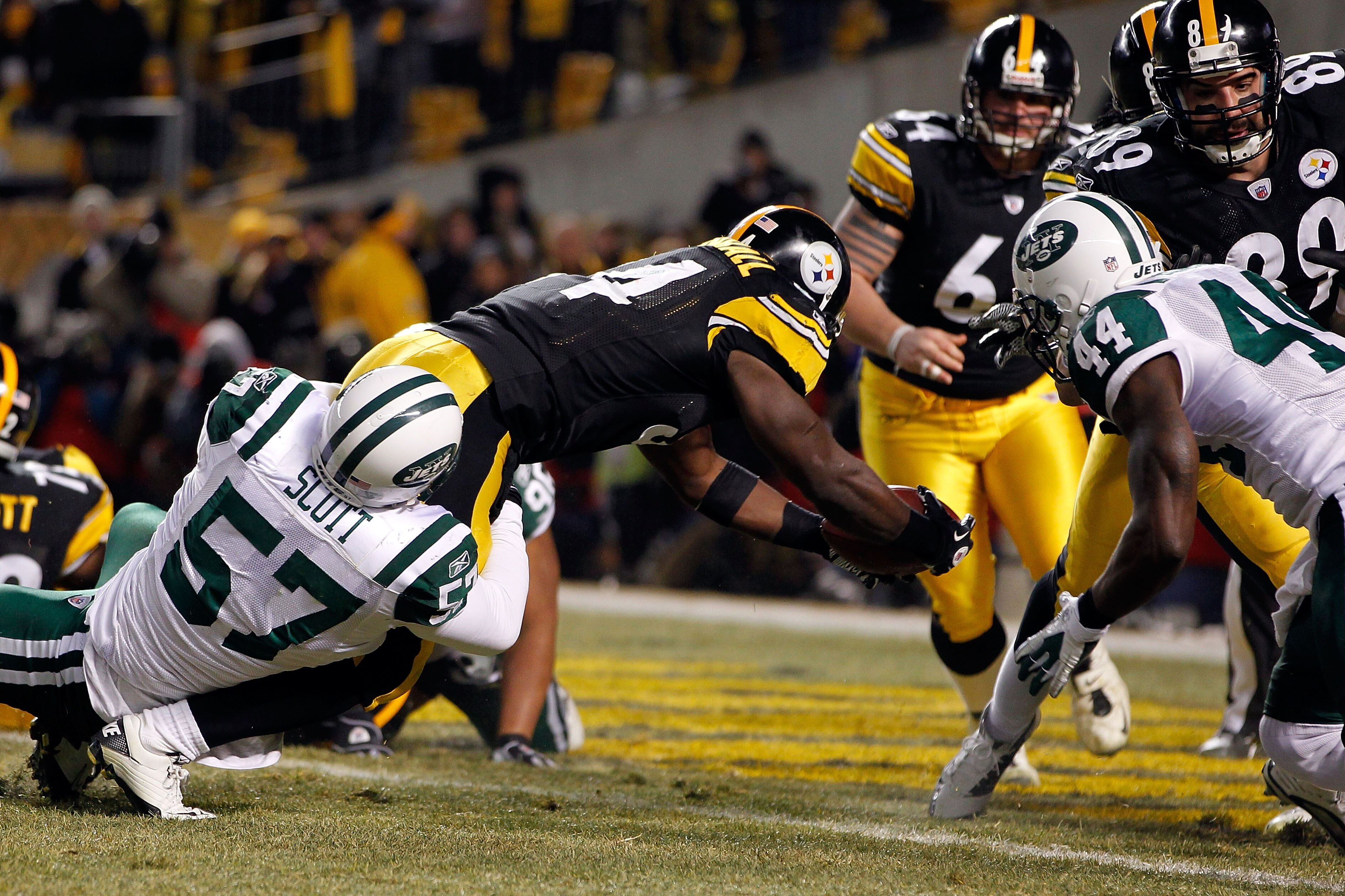 PITTSBURGH, PA - JANUARY 23:  Rashard Mendenhall #34 of the Pittsburgh Steelers scores a first quarter touchdown as Bart Scott #57 and James Ihedigbo #44 of the New York Jets attemps to tackle during the 2011 AFC Championship game at Heinz Field on Januar