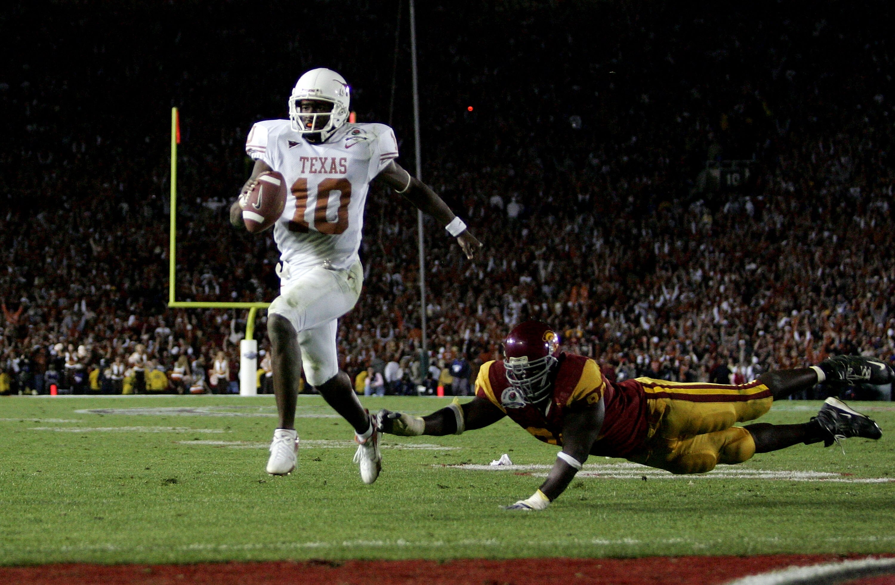 PASADENA, CA - JANUARY 04:  Vince Young #10 of the Texas Longhorns runs past Frostee Rucker #90 of the USC Trojans to score a touchdown and put the Longhorns up by one in the final moments of the BCS National Championship Rose Bowl Game at the Rose Bowl o