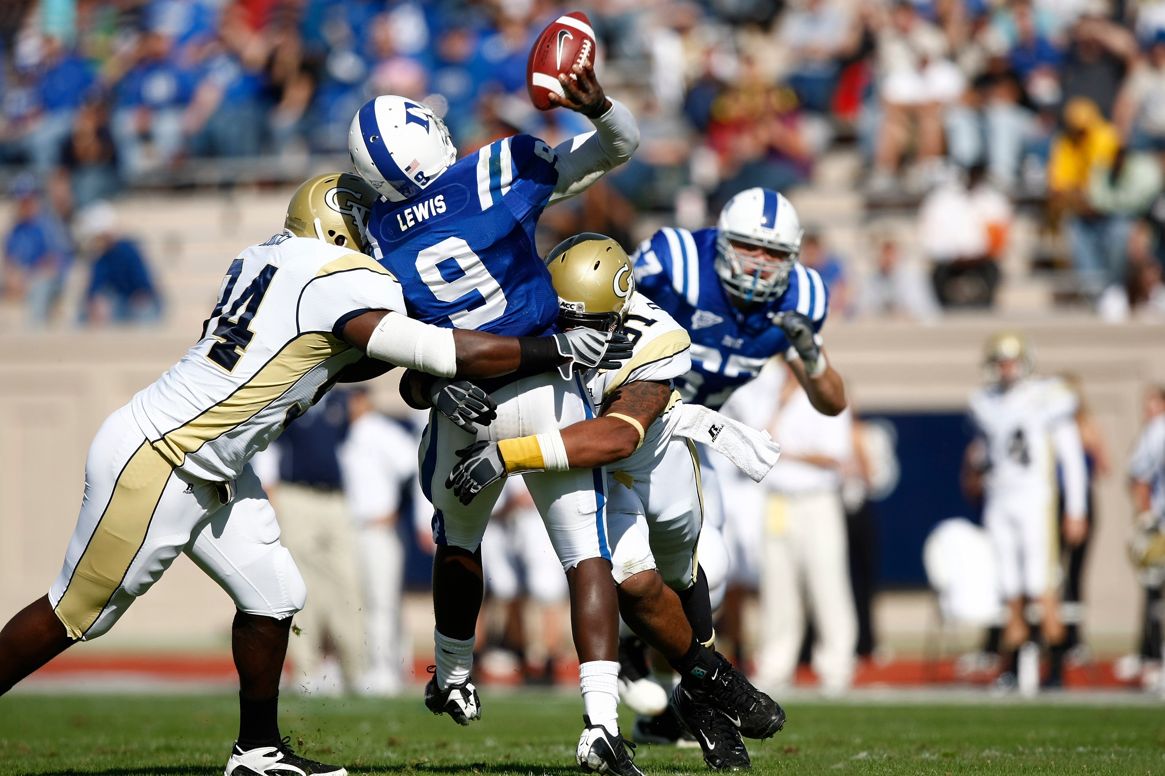 DURHAM, NC - NOVEMBER 14:  Thaddeus Lewis #9 of the Duke Blue Devils throws a pass while being hit by Izaan Cross #94 and Derrick Morgan #91 of the Georgia Tech Yellow Jackets during first half action at Wallace Wade Stadium on November 14, 2009 in Durham
