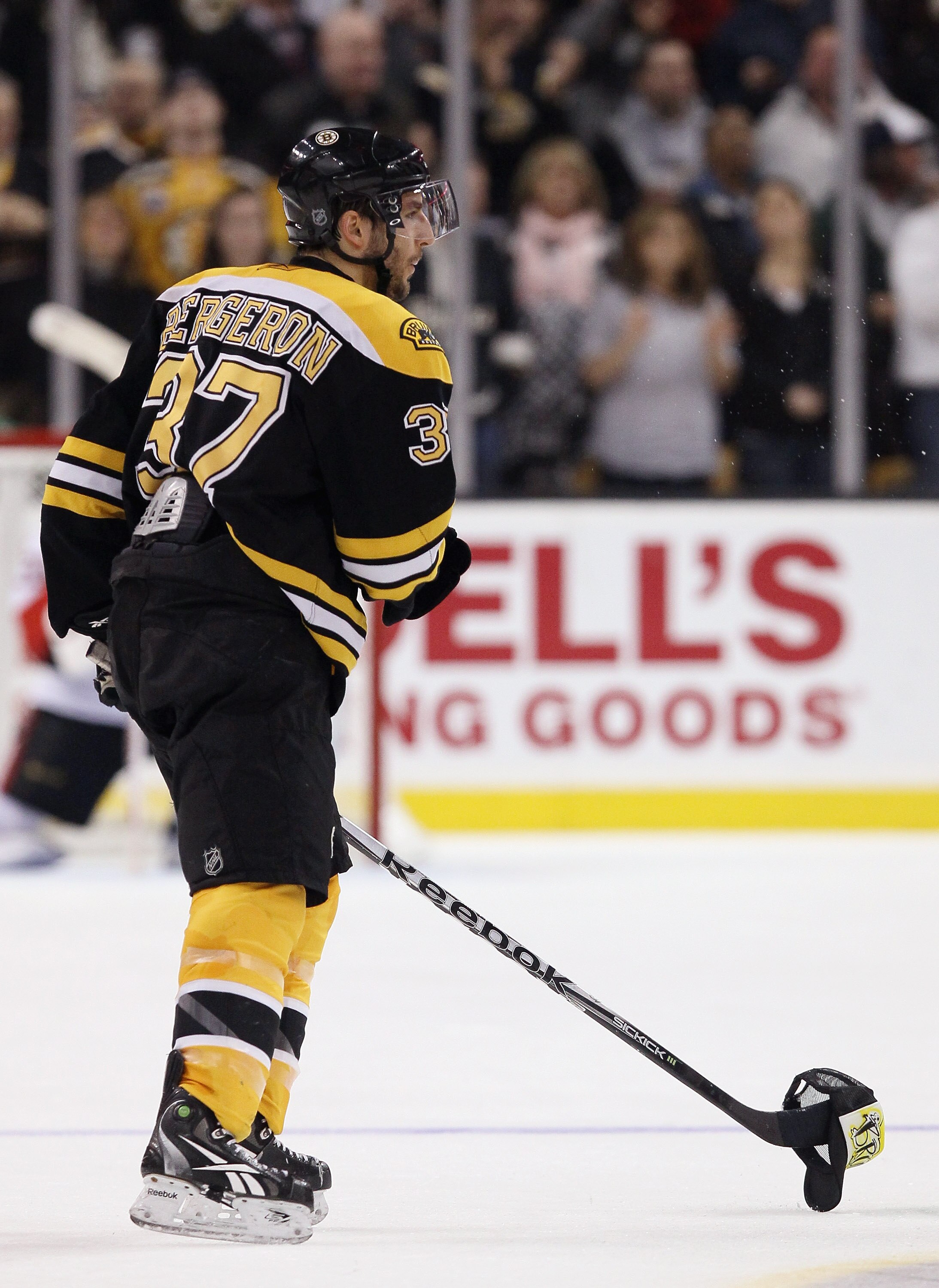 BOSTON, MA - JANUARY 11:  Patrice Bergeron #37 of the Boston Bruins picks up a hat thrown on the ice after he scored a hat trick in the second period against the Ottawa Senators on January 11, 2011 at the TD Garden in Boston, Massachusetts.  (Photo by Els