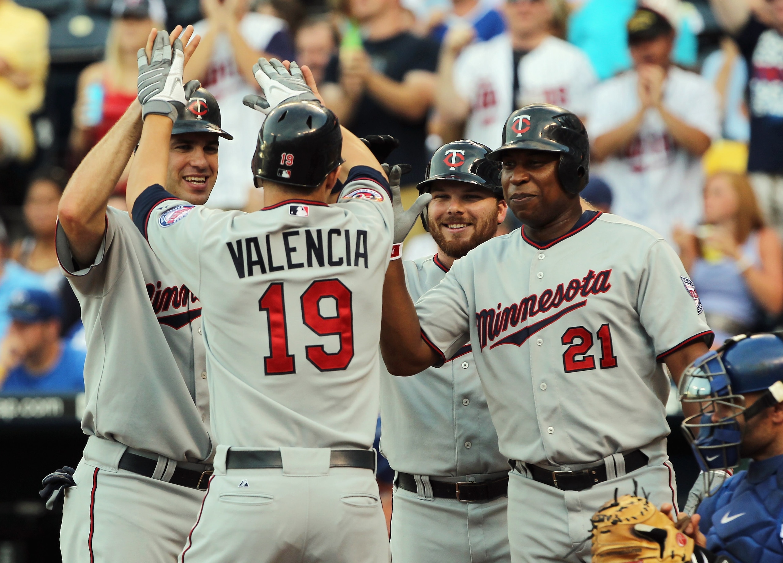 KANSAS CITY, MO - JULY 26: Danny Valencia #19 of the Minnesota Twins is congratulated by teammates Joe Mauer #7, Jason Kubel #16 and Delmon Young #21 at home plate after hitting a grand slam home run during the 1st inning of the game against the Kansas C KANSAS CITY, MO - JULY 26: Danny Valencia #19 of the Minnesota Twins is congratulated by teammates Joe Mauer #7, Jason Kubel #16 and Delmon Young #21 at home plate after hitting a grand slam home run during the 1st inning of the game against the Kansas C