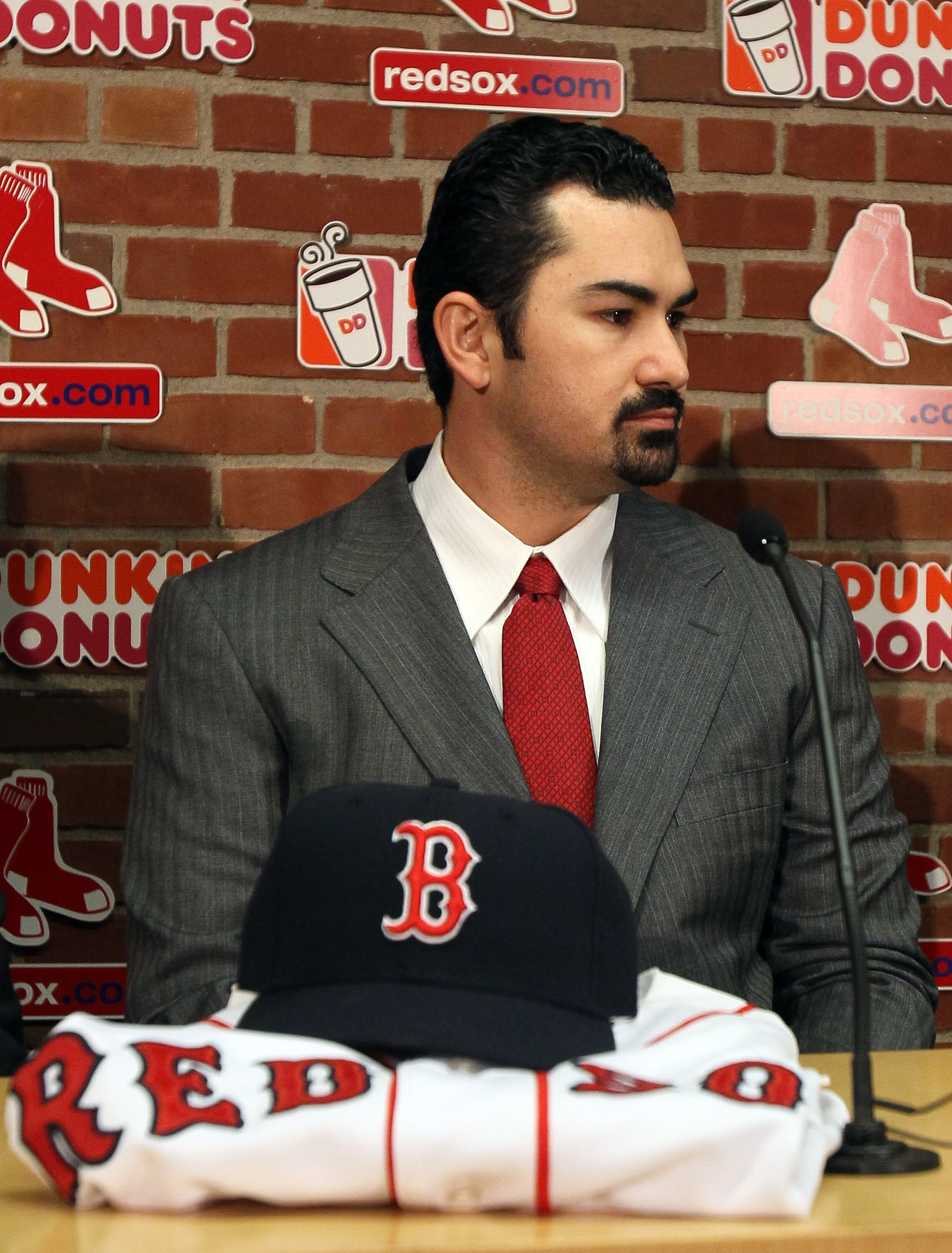 BOSTON, MA - DECEMBER 06:  Adrian Gonzalez answers questions during a press conference to announce his signing with the Boston Red Sox on December 6,  2010 at Fenway Park in Boston, Massachusetts.  (Photo by Elsa/Getty Images)