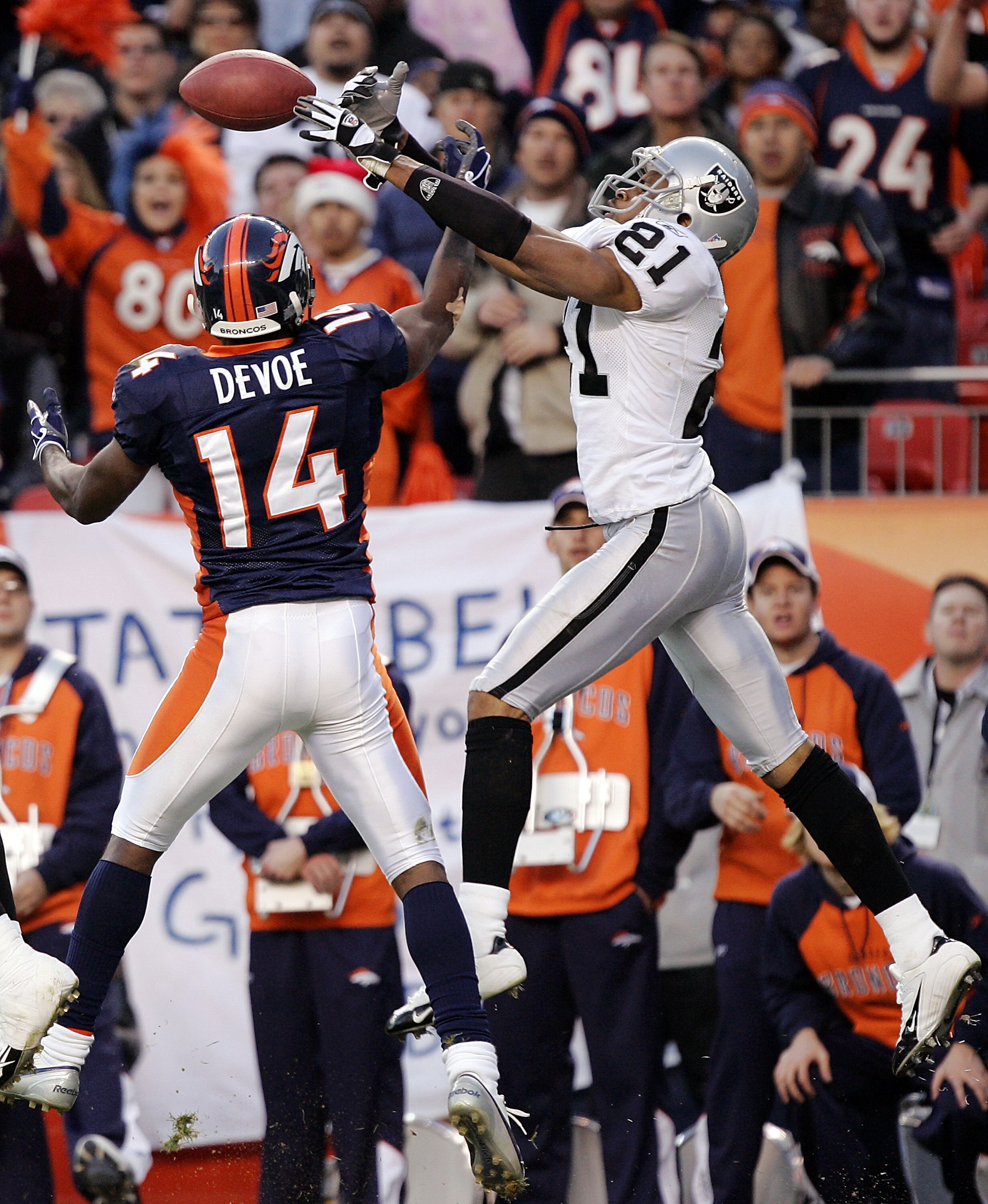 DENVER - DECEMBER 24:  Cornerback Nnamdi Asomugha #21 of the Oakland Raiders breaks up a pass intended for wide receiver Todd Devoe #14 of the Denver Broncos in the third quarter on December 24, 2005 at Invesco Field at Mile High in Denver, Colorado. The 