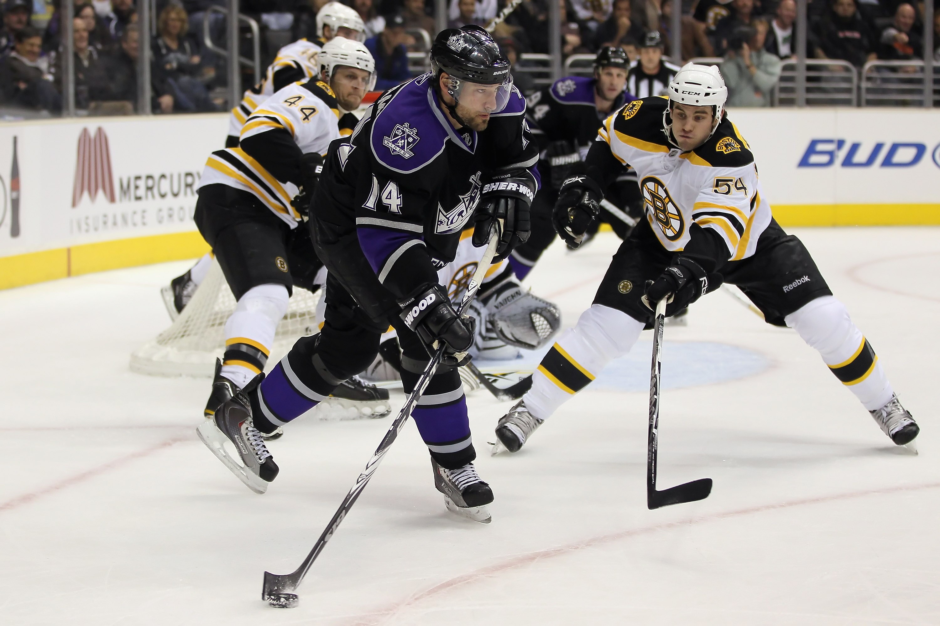 LOS ANGELES, CA - JANUARY 24:  Justin Williams #14 of the Los Angeles Kings is pursued by Adam McQuaid #54 of the Boston Bruins for the puck during the second period at Staples Center on January 24, 2011 in Los Angeles, California. The Kings defeated the