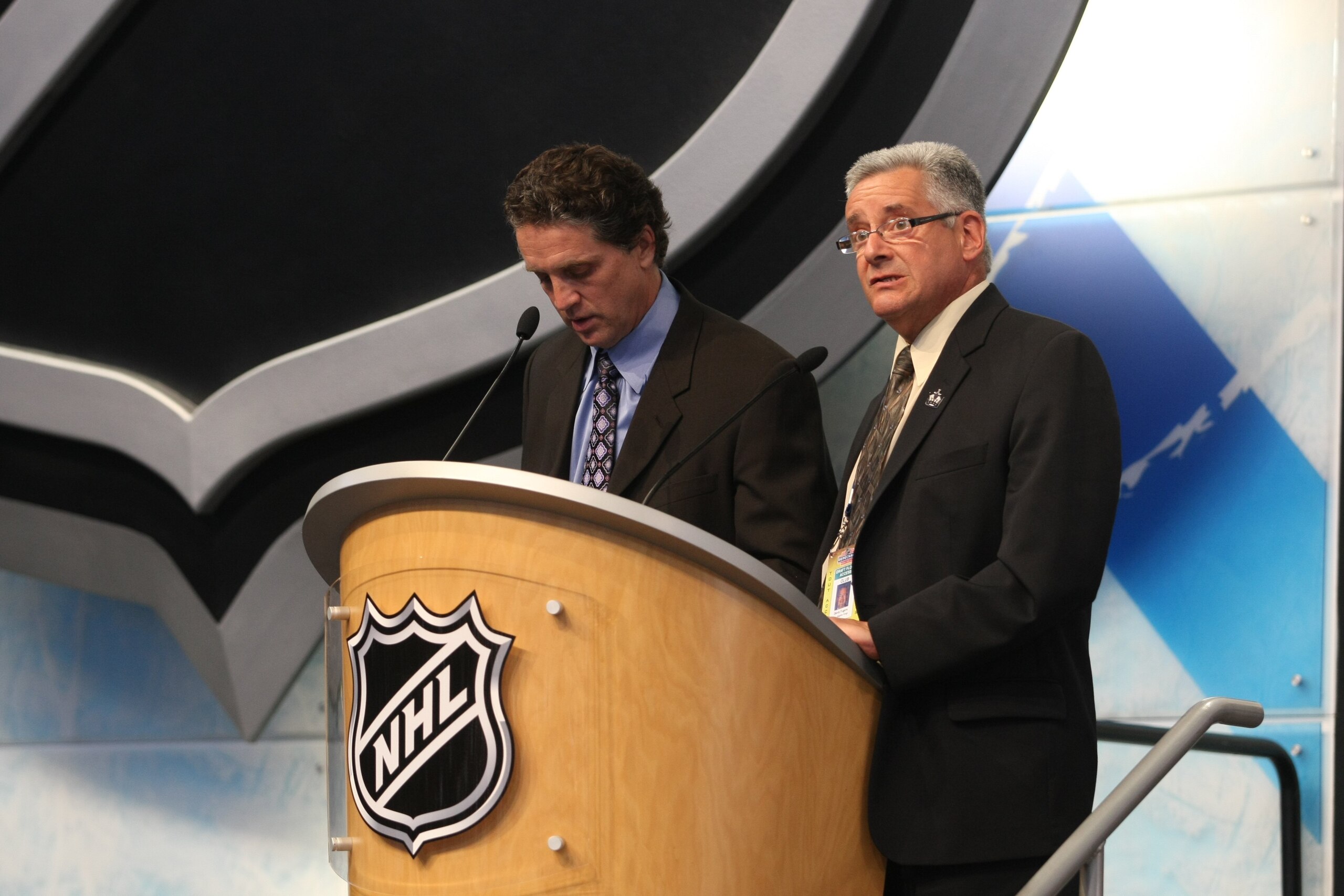 MONTREAL - JUNE 26:  Los Angeles Kings President/GM Dean Lombardi speaks at the podium as Amateur Scout - Europe Denis Fugere looks on during the first round of the 2009 NHL Entry Draft at the Bell Centre on June 26, 2009 in Montreal, Quebec, Canada. (Pho