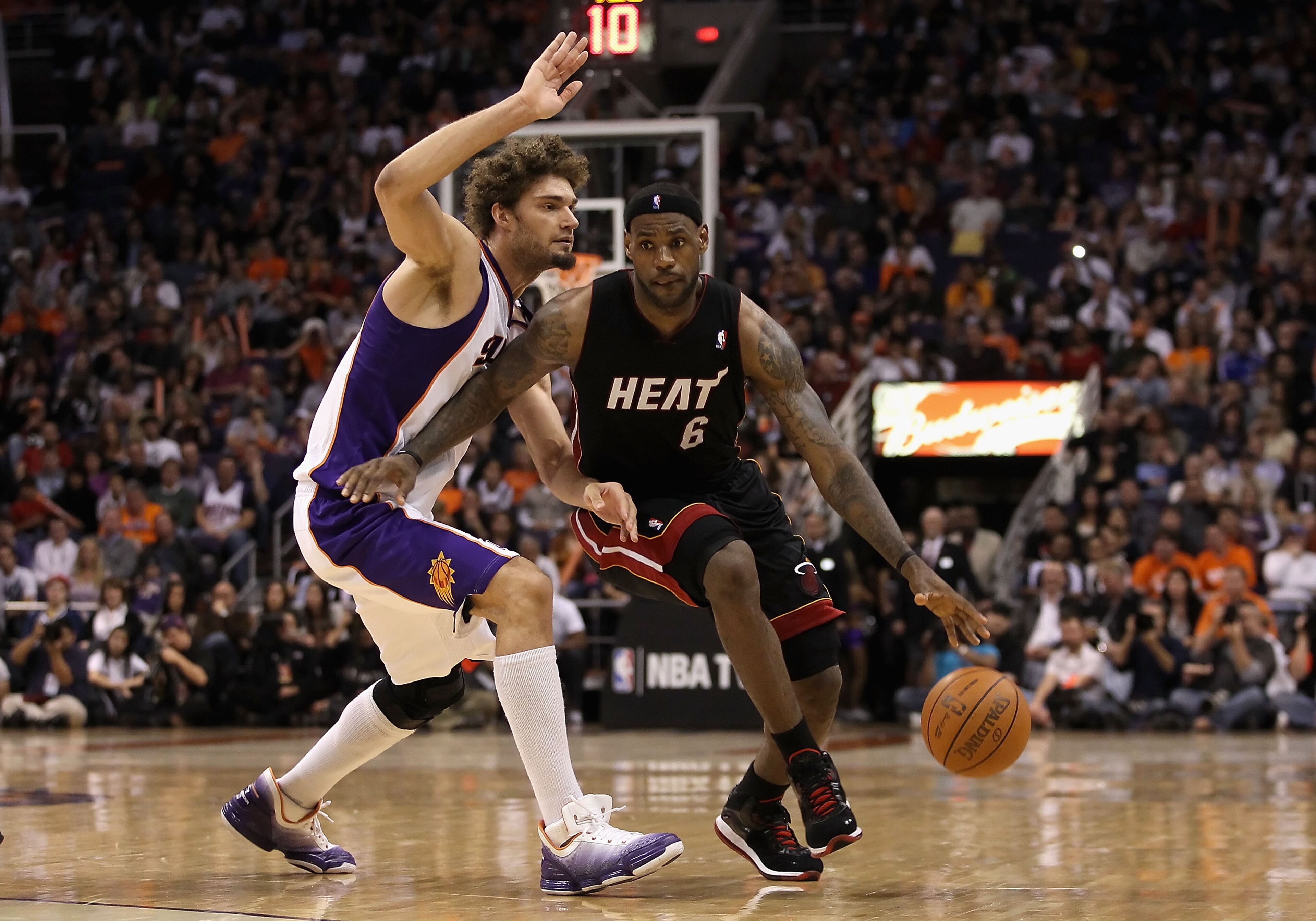 PHOENIX - DECEMBER 23:  LeBron James #6 of the Miami Heat drives the ball past Robin Lopez #15 of the Phoenix Suns during the NBA game at US Airways Center on December 23, 2010 in Phoenix, Arizona. The Heat defeated the Suns 95-83.  NOTE TO USER: User exp