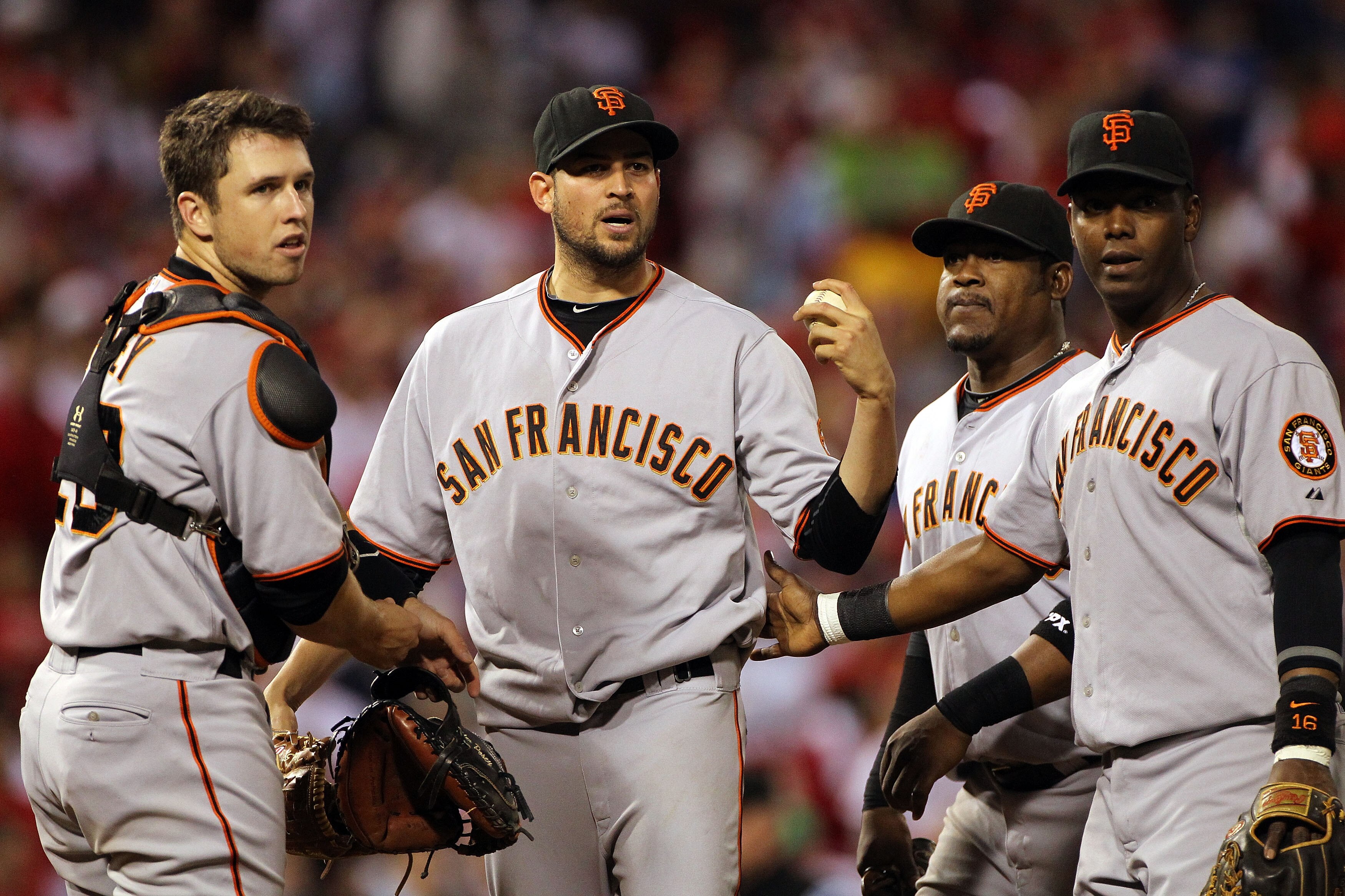 PHILADELPHIA - OCTOBER 23:  Jonathan Sanchez #57 of the San Francisco Giants is held back by teammates Buster Posey #28, Juan Uribe #5, and Edgar Renteria #16 after hitting Chase Utley of the Philadelphia Phillies with a pitch in the third inning in Game