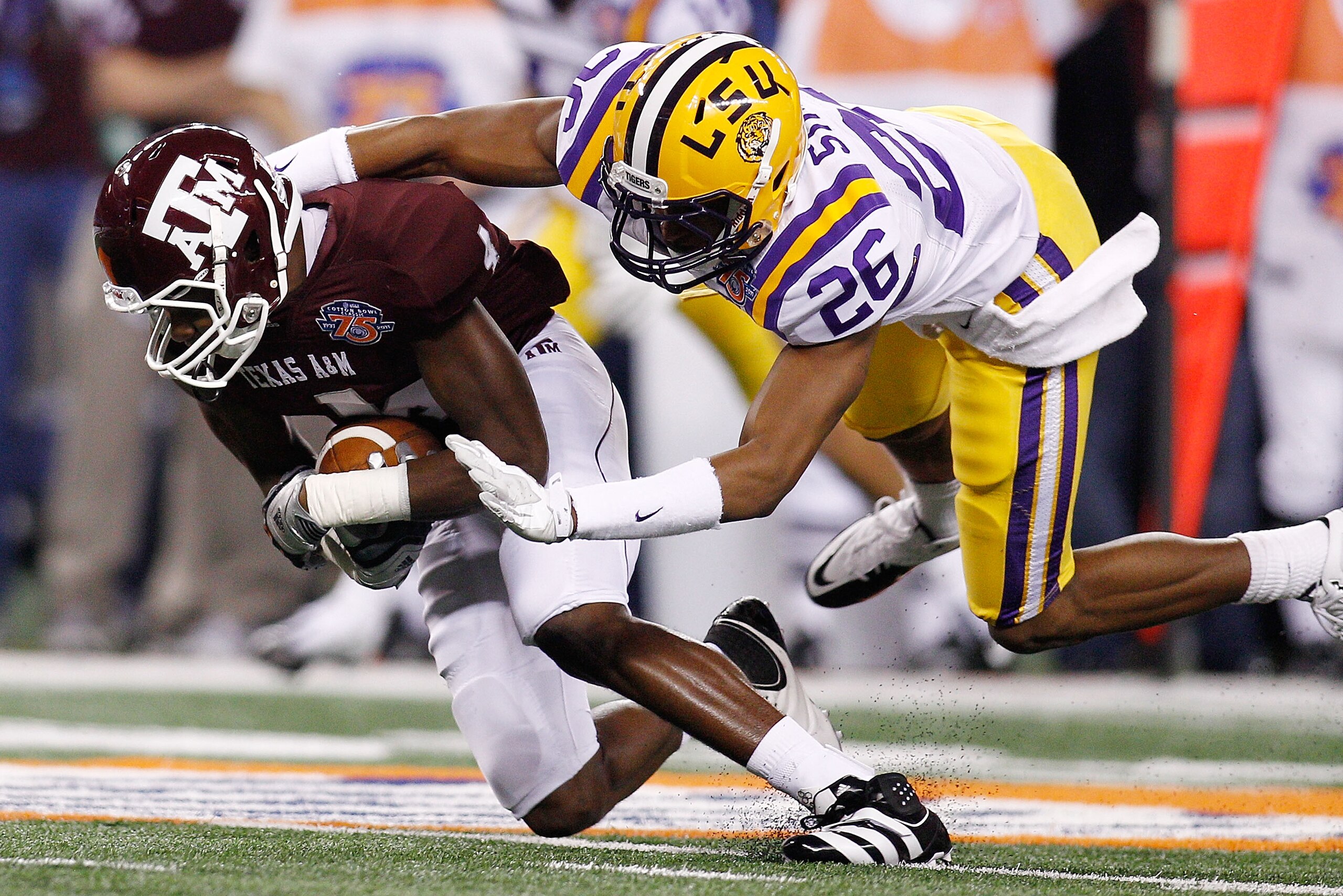 ARLINGTON, TX - JANUARY 07:  Brandal Jackson #4 of the Texas A&M Aggies is tackled by Tharold Simon #26 of the Louisiana State University Tigers during the AT&T Cotton Bowl at Cowboys Stadium on January 7, 2011 in Arlington, Texas.  (Photo by Chris Grayth