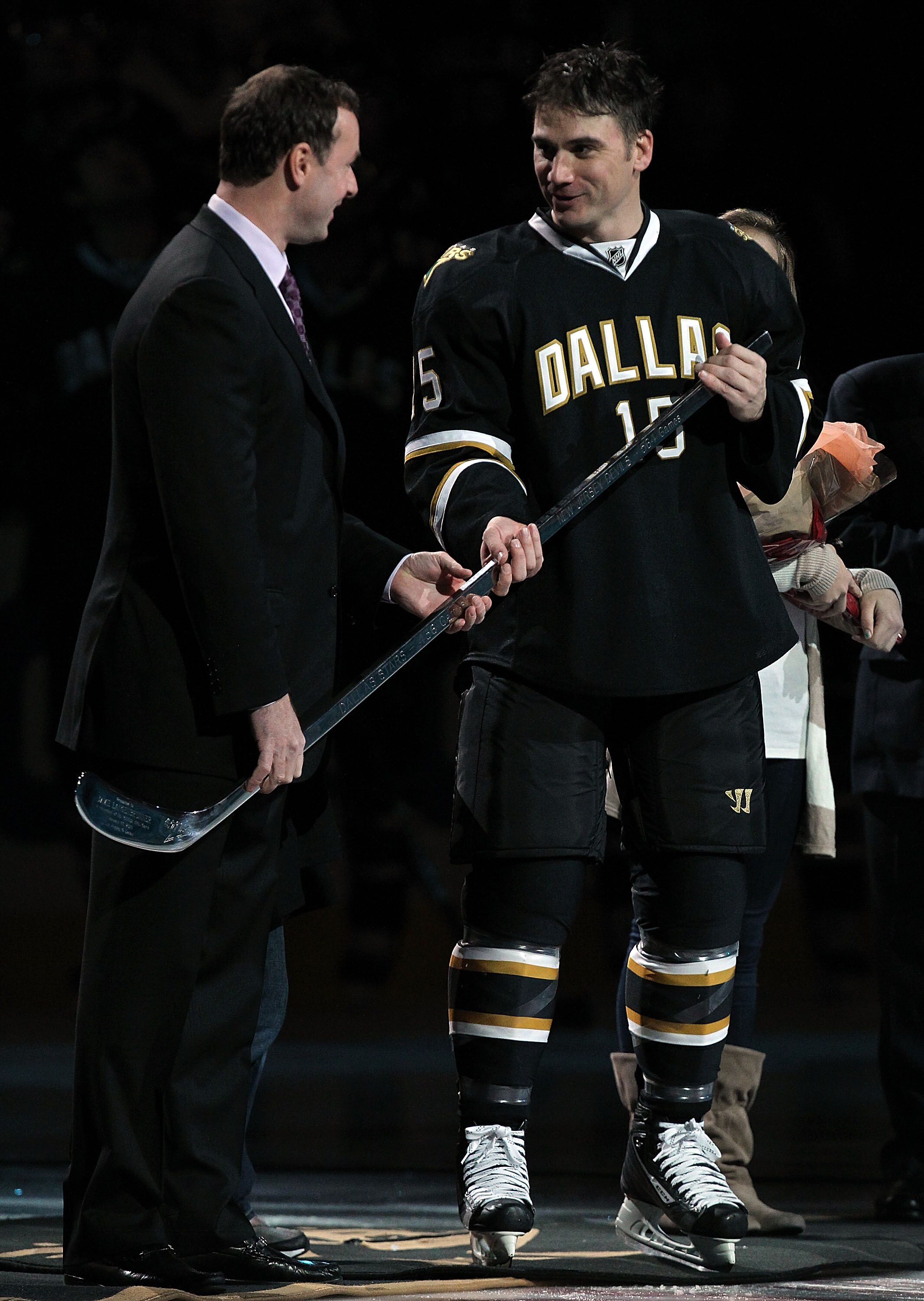 DALLAS, TX - JANUARY 17:  Jamie Langenbrunner #15 of the Dallas Stars receives a silver hockey stick from Joe Nieuwendyk to commemorate his 1,000 career NHL game before play against the Los Angeles Kings at American Airlines Center on January 17, 2011 in