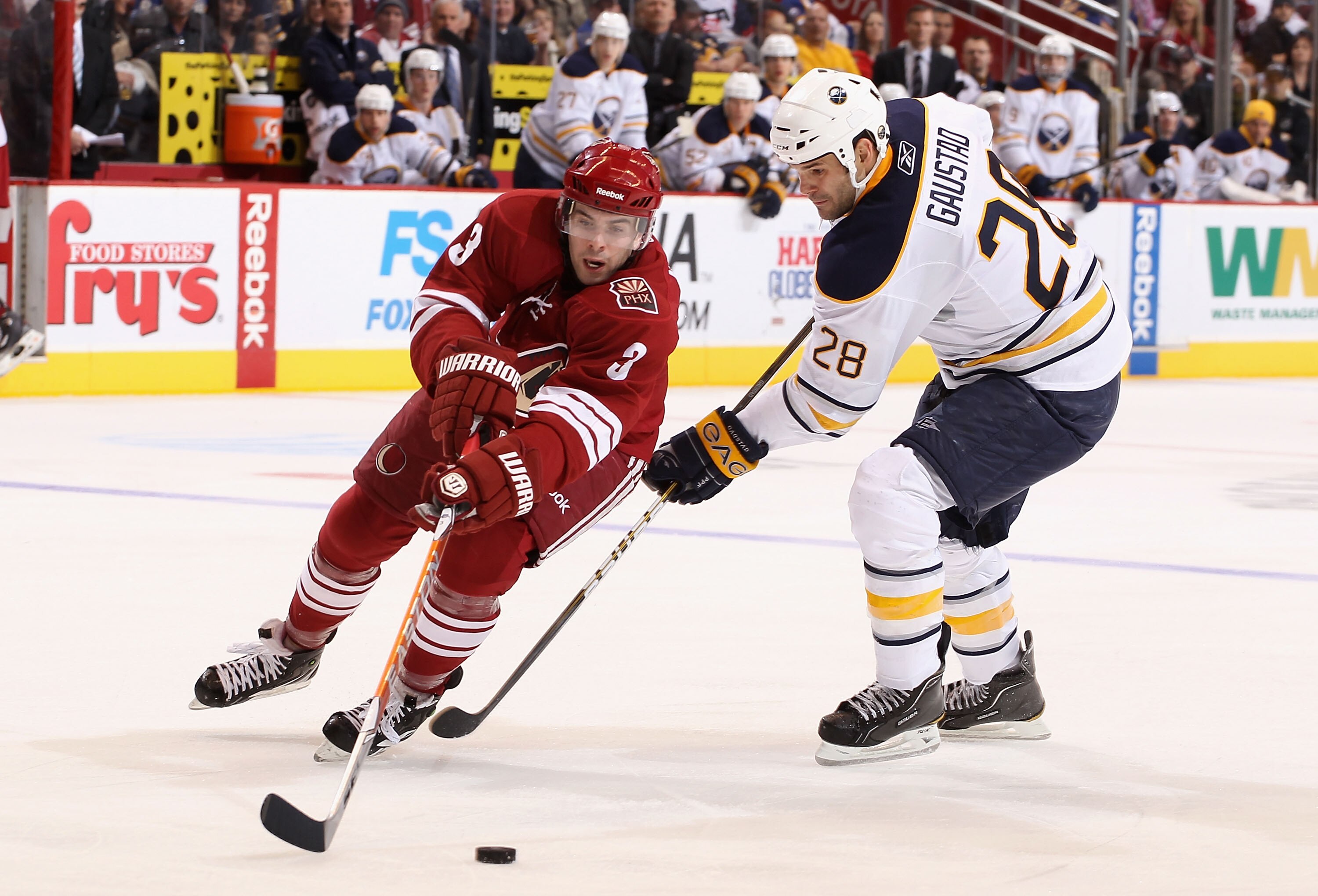 GLENDALE, AZ - JANUARY 08:  Keith Yandle #3 of the Phoenix Coyotes skates after the puck under pressure from Paul Gaustad #28 of the Buffalo Sabres during the NHL game at Jobing.com Arena on January 8, 2011 in Glendale, Arizona. The Sabres defeated the Co