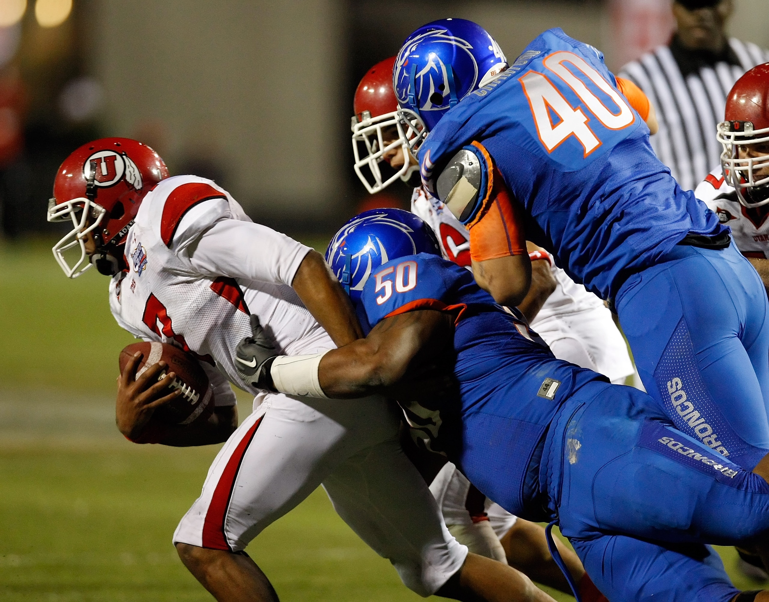 LAS VEGAS, NV - DECEMBER 22: Quarterback Terrance Cain #7 of the Utah Utes is sacked by J.P. Nisby #50 of the Boise State Broncos as Boise State's Tyrone Crawford #40 defends during the MAACO Bowl Las Vegas at Sam Boyd Stadium December 22, 2010 in Las Ve LAS VEGAS, NV - DECEMBER 22: Quarterback Terrance Cain #7 of the Utah Utes is sacked by J.P. Nisby #50 of the Boise State Broncos as Boise State's Tyrone Crawford #40 defends during the MAACO Bowl Las Vegas at Sam Boyd Stadium December 22, 2010 in Las Ve