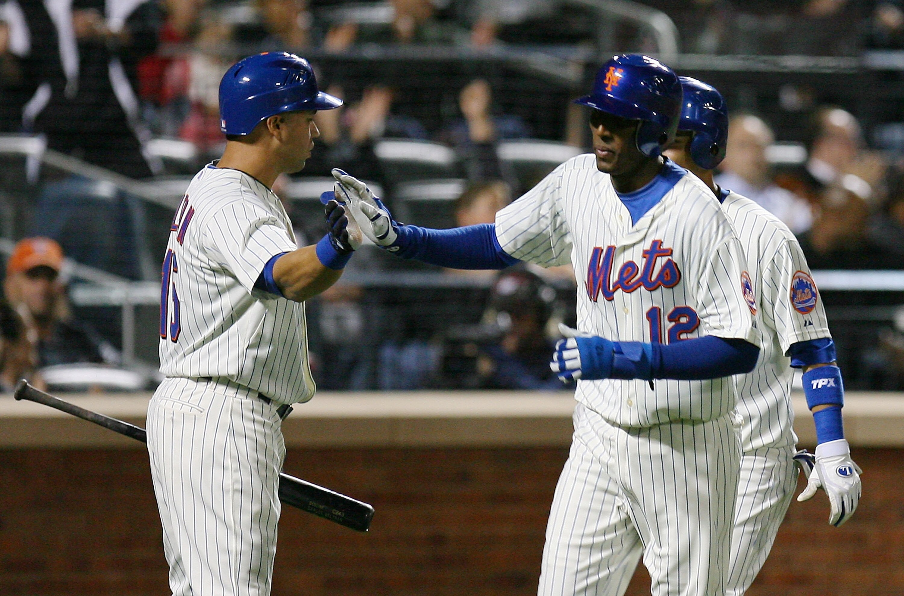 NEW YORK - SEPTEMBER 15:  Joaquin Arias #12 (C) of the New York Mets celebrates with Carlos Beltran #15 (L) after scoring a run in the fourth inning against the Pittsburgh Pirates on September 15, 2010 at Citi Field in the Flushing neighborhood of the Que