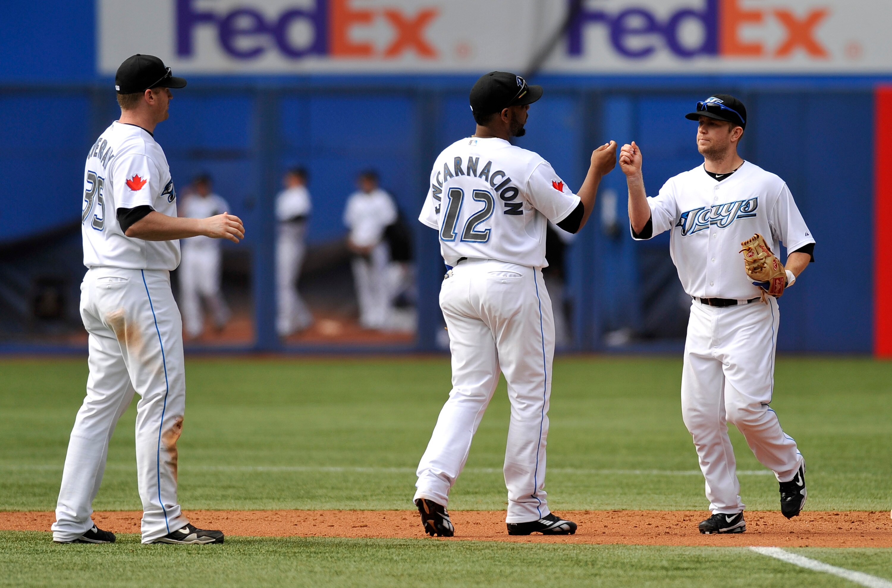 TORONTO - SEPTEMBER 23:   Lyle Overbay #35, Edwin Encarnacion #12 and Aaron Hill #2 of the Toronto Blue Jays celebrate the teams win over the Seattle Mariners during game action September 23, 2010 at Rogers Centre in Toronto, Ontario, Canada. (Photo by Br