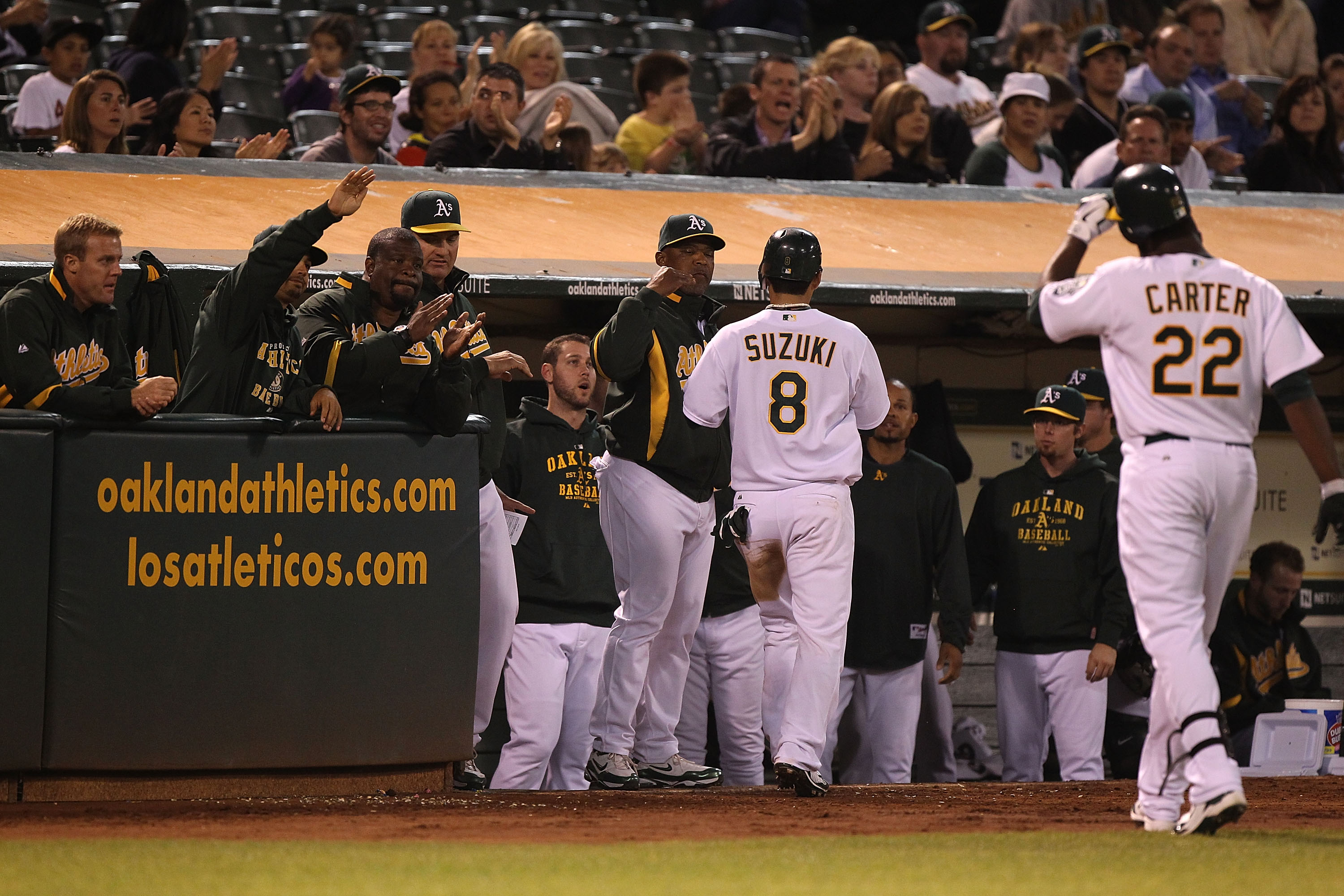 OAKLAND, CA - SEPTEMBER 23:  Chirs Carter #22 of the Oakland Athletics celebrates with Kurt Suzuki #8 after hitting an RBI sacrafice fly against the Texas Rangers in the fourth inning during a Major League Baseball game at the Oakland-Alameda County Colis