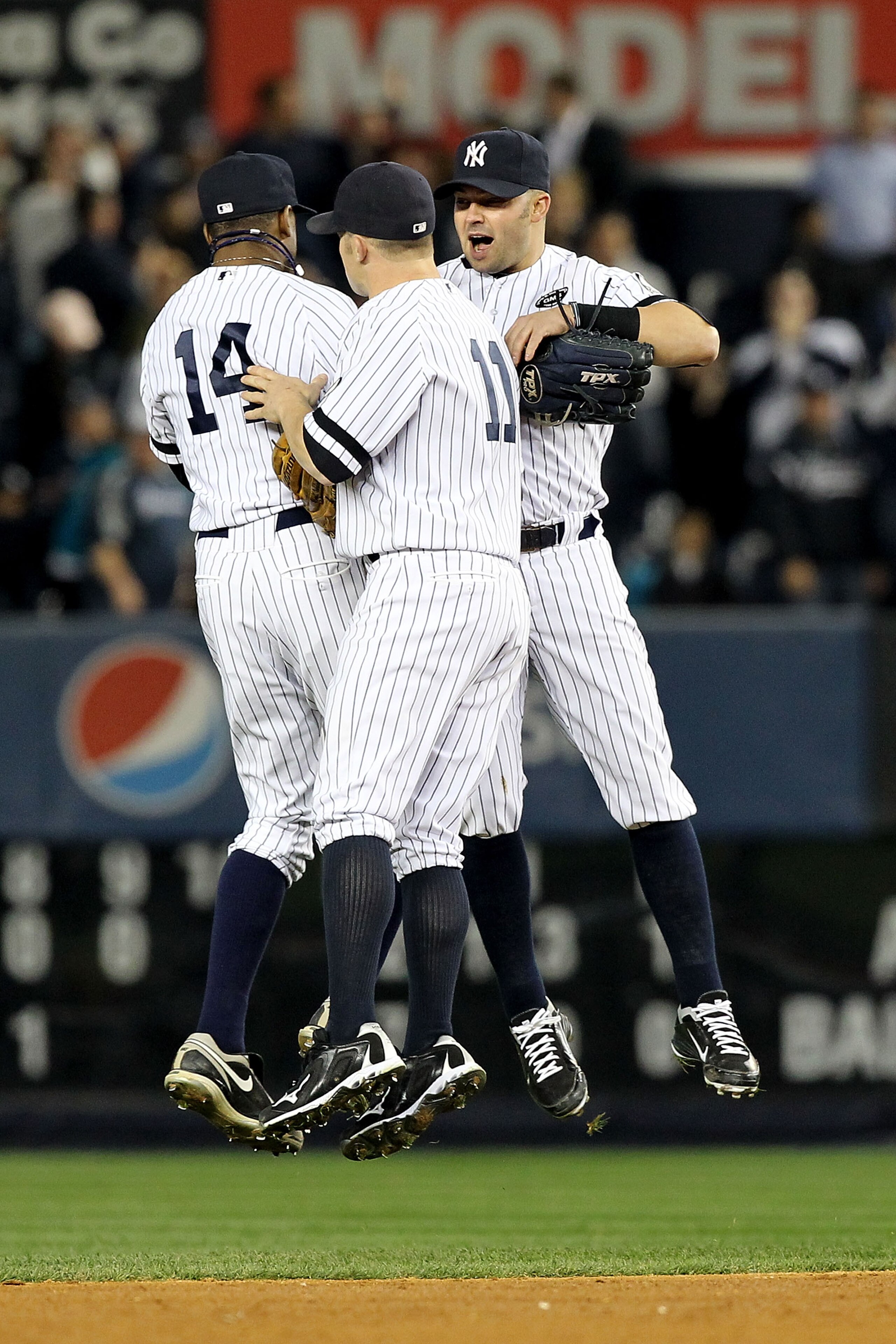 NEW YORK - OCTOBER 20:  Curtis Granderson #14, Brett Gardner #11 and Nick Swisher #33 of the New York Yankees celebrate after the Yankees won 7-2 against the Texas Rangers in Game Five of the ALCS during the 2010 MLB Playoffs at Yankee Stadium on October 