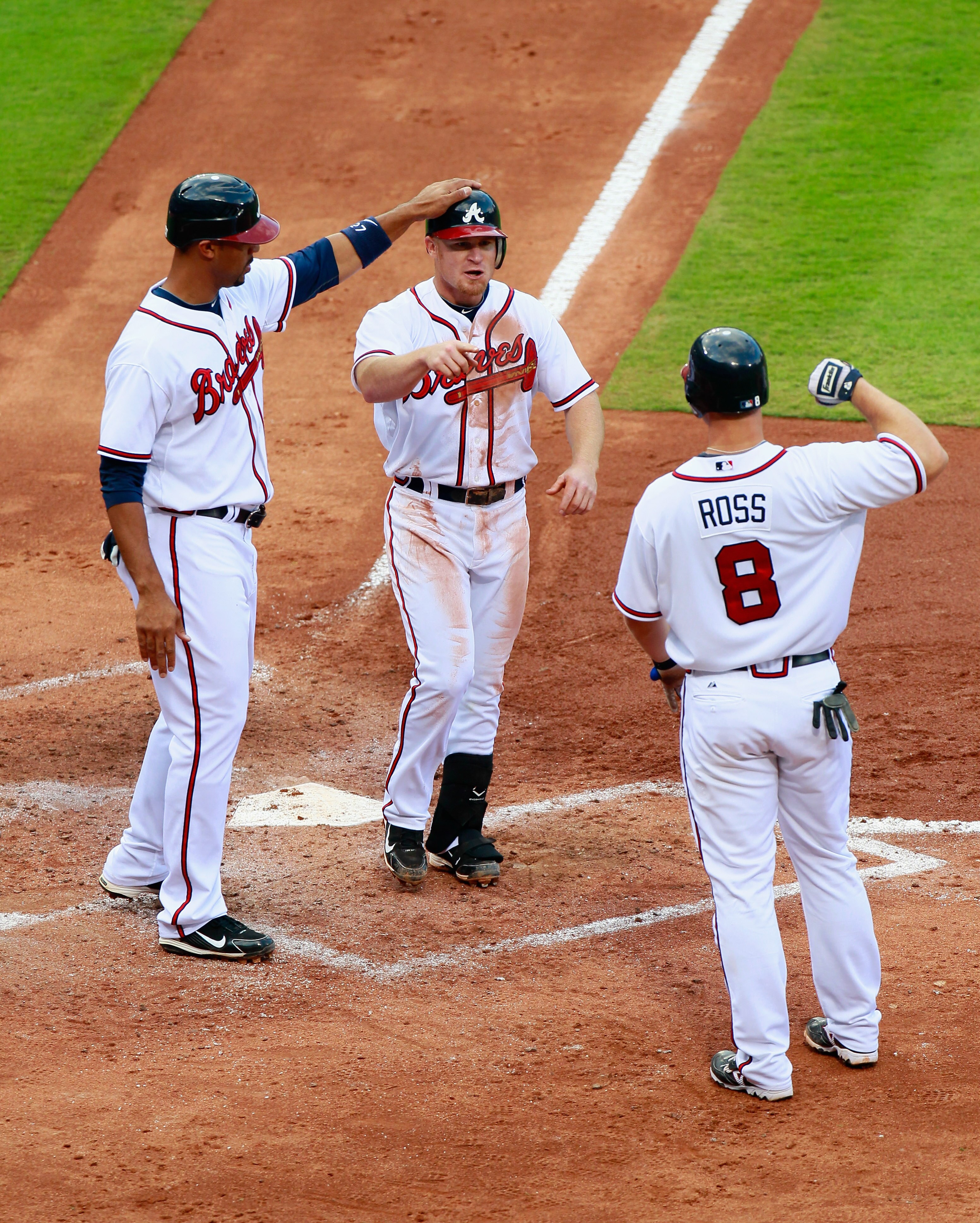 ATLANTA - SEPTEMBER 29:  Brooks Conrad #26 of the Atlanta Braves celebrates with Derrek Lee #27 and David Ross #8 after hitting a three-run homer in the third inning against the Florida Marlins at Turner Field on September 29, 2010 in Atlanta, Georgia.  (