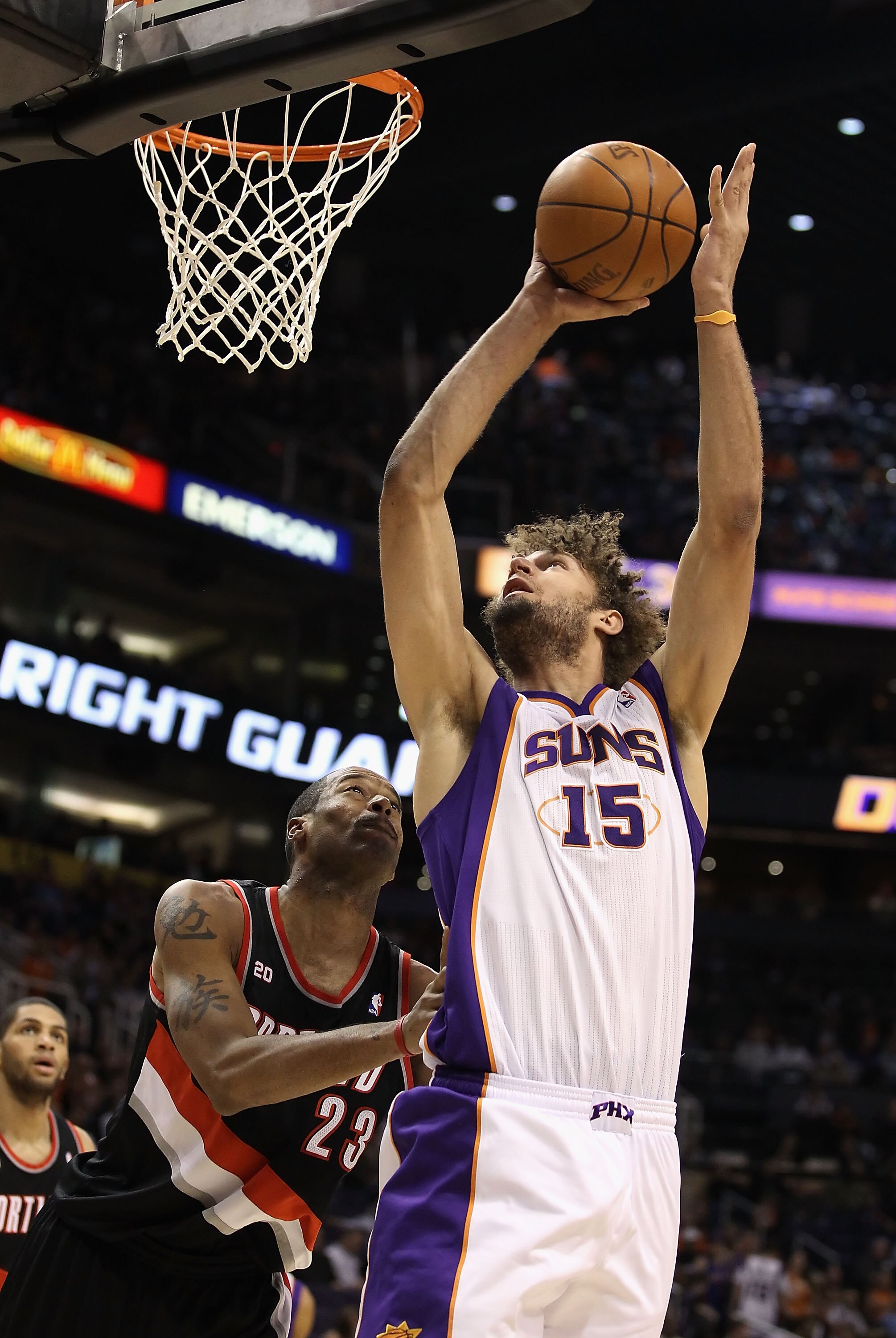 PHOENIX, AZ - JANUARY 14:  Robin Lopez #15 of the Phoenix Suns puts up a shot over Marcus Camby #23 of the Portland Trail Blazers during the NBA game at US Airways Center on January 14, 2011 in Phoenix, Arizona.  The Suns defeated the 115-111.  NOTE TO US
