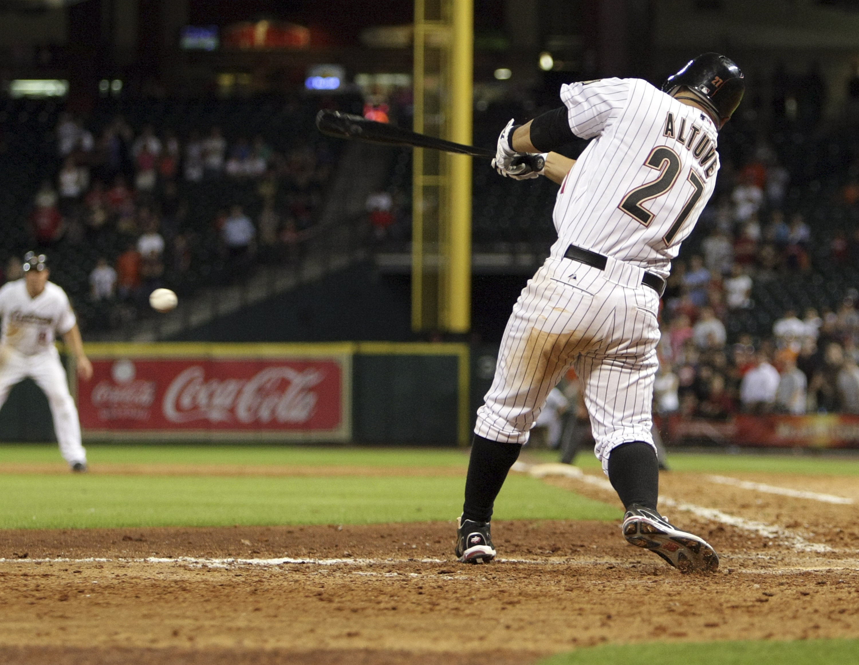HOUSTON - AUGUST 01:  Jose Altuve #27 of the Houston Astros drives the ball up the middle for a fielders choice in the 10th inning scoring Humberto Quintero #51 from third base after the throw to home could not be handled by catcher Ryan Hanigan #29 at Mi
